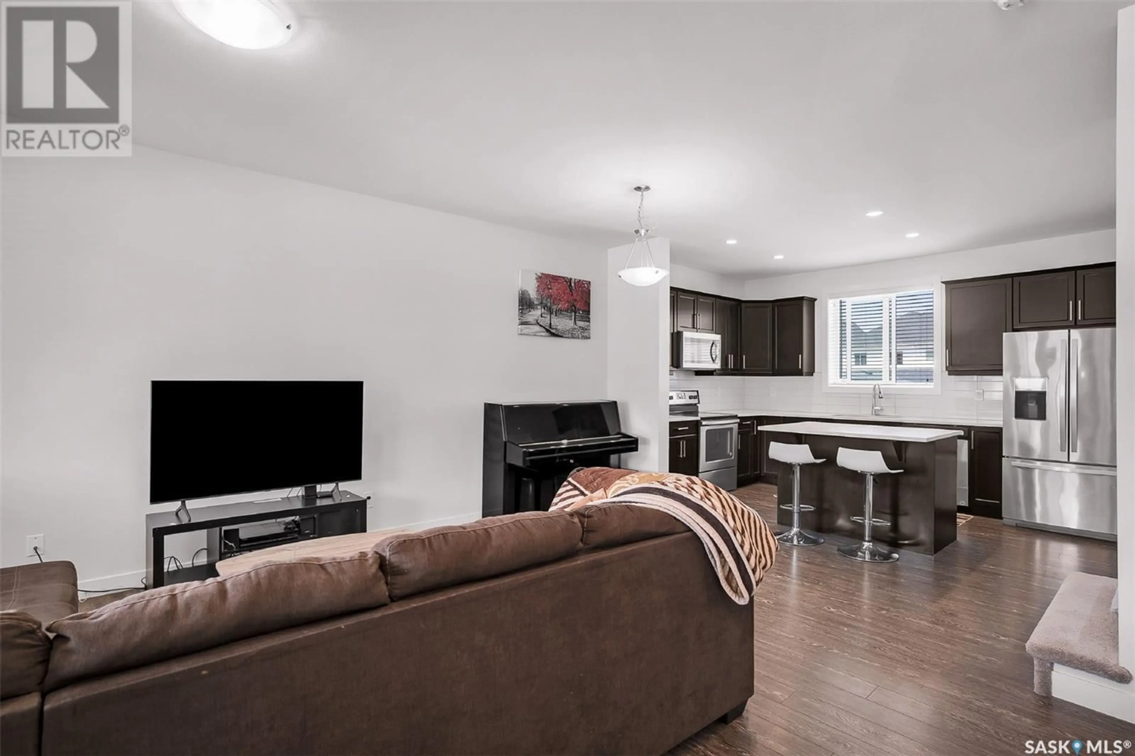 Living room with furniture, wood/laminate floor for 247 NEWTON LINK, Saskatoon Saskatchewan S7V0M8
