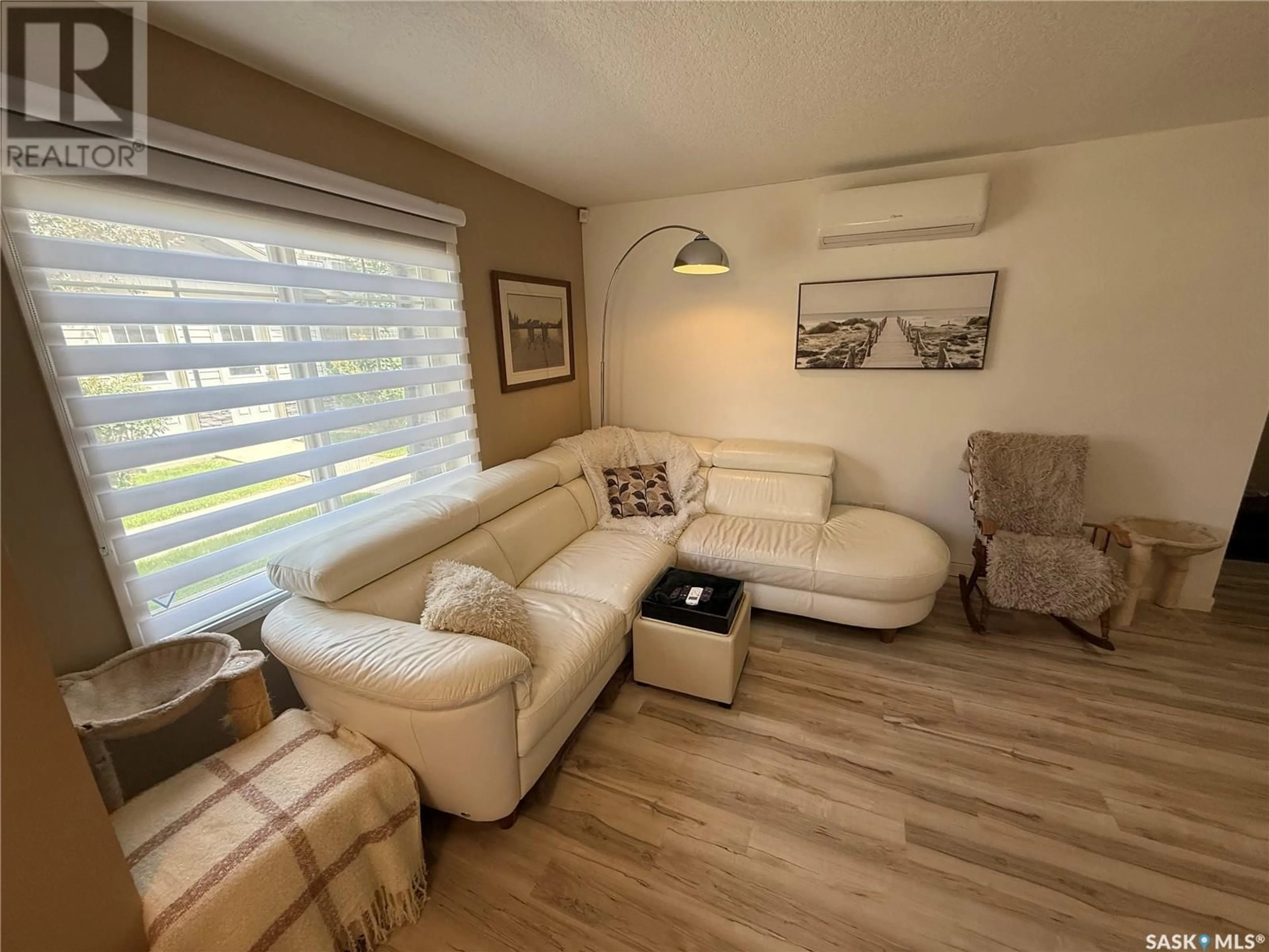 Living room with furniture, wood/laminate floor for 42 - 5541 BLAKE CRESCENT, Regina Saskatchewan S4X0J1