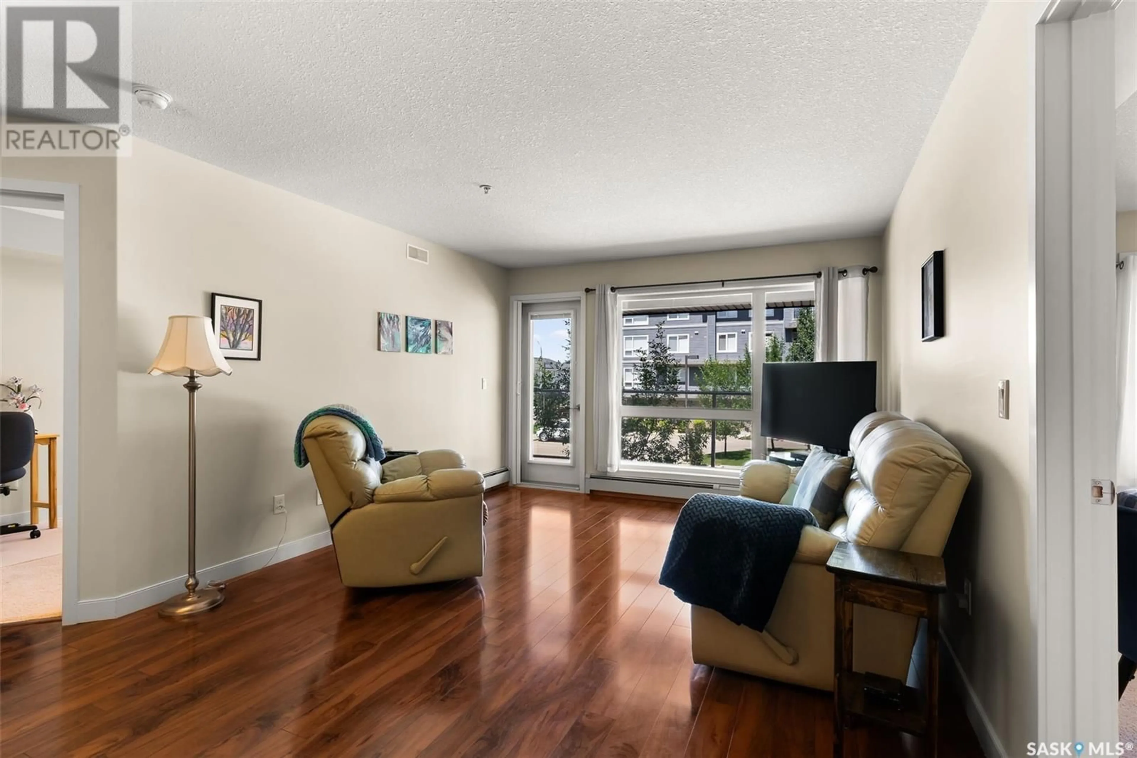 Living room with furniture, wood/laminate floor for 110 2341 WINDSOR PARK ROAD, Regina Saskatchewan S4V1R7