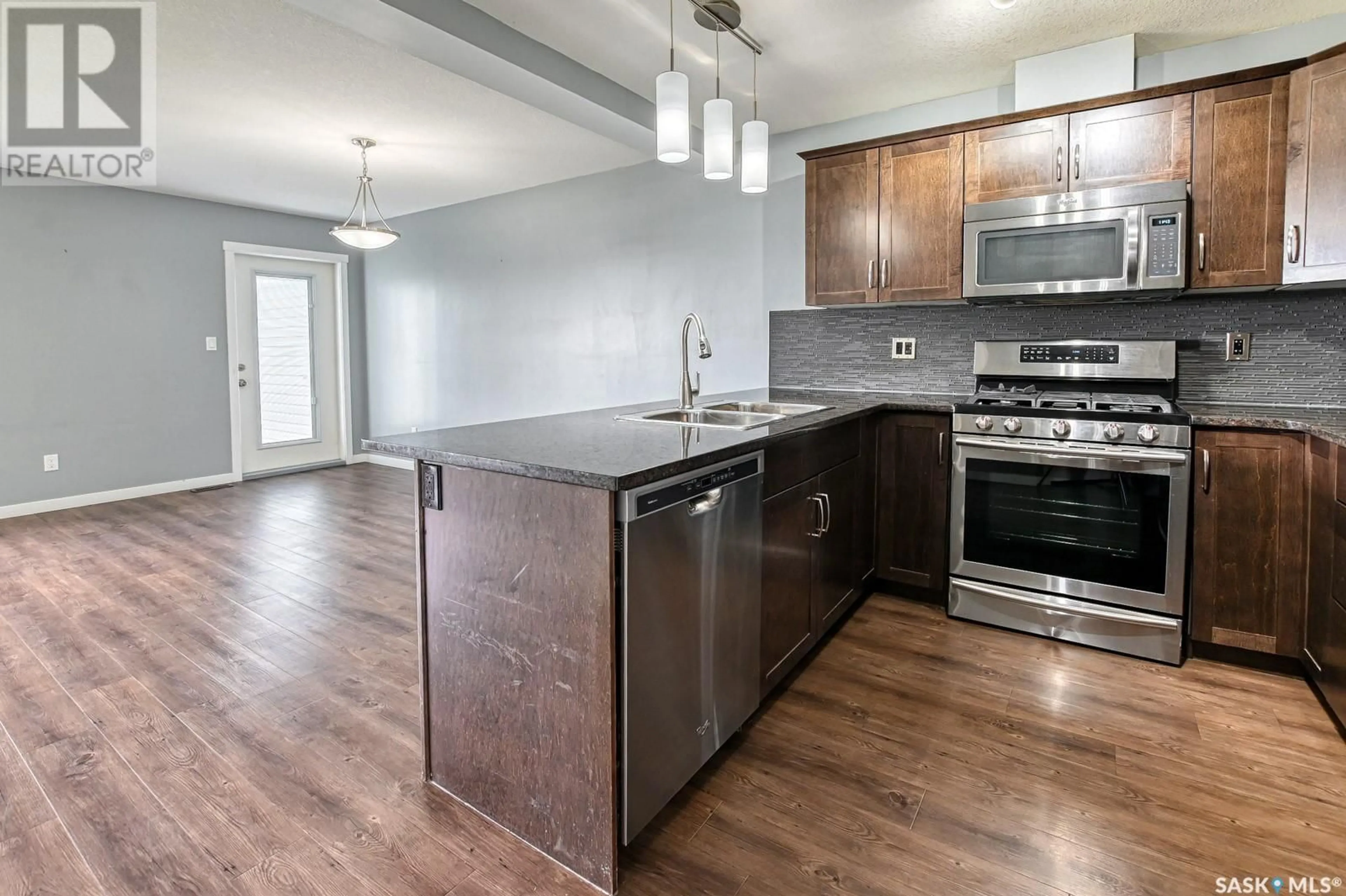 Open concept kitchen, wood/laminate floor for 204 2 SAVANNA CRESCENT, Pilot Butte Saskatchewan S0G3Z0