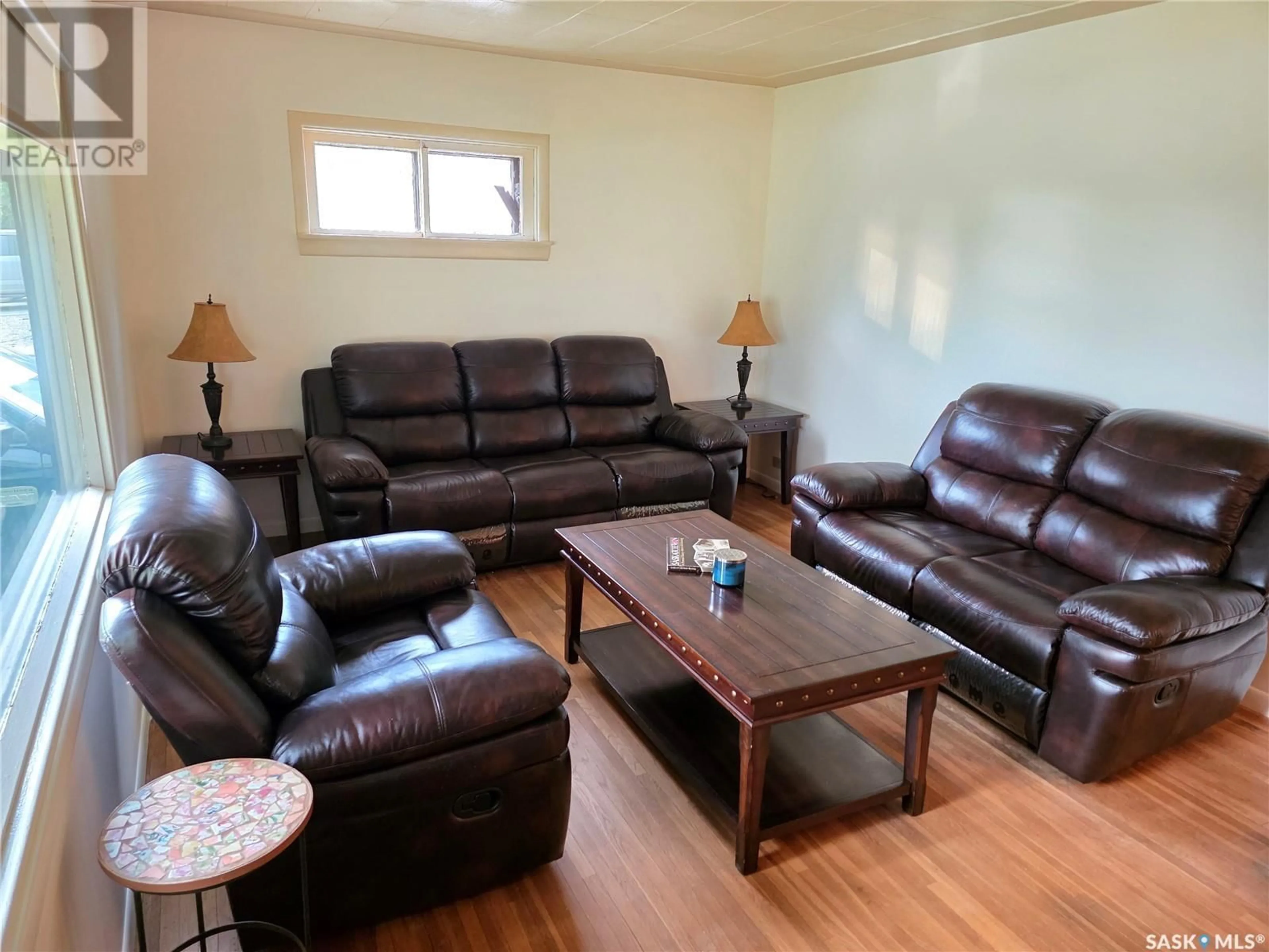 Living room with furniture, wood/laminate floor for 113 1ST STREET, Milden Saskatchewan S0L2L0