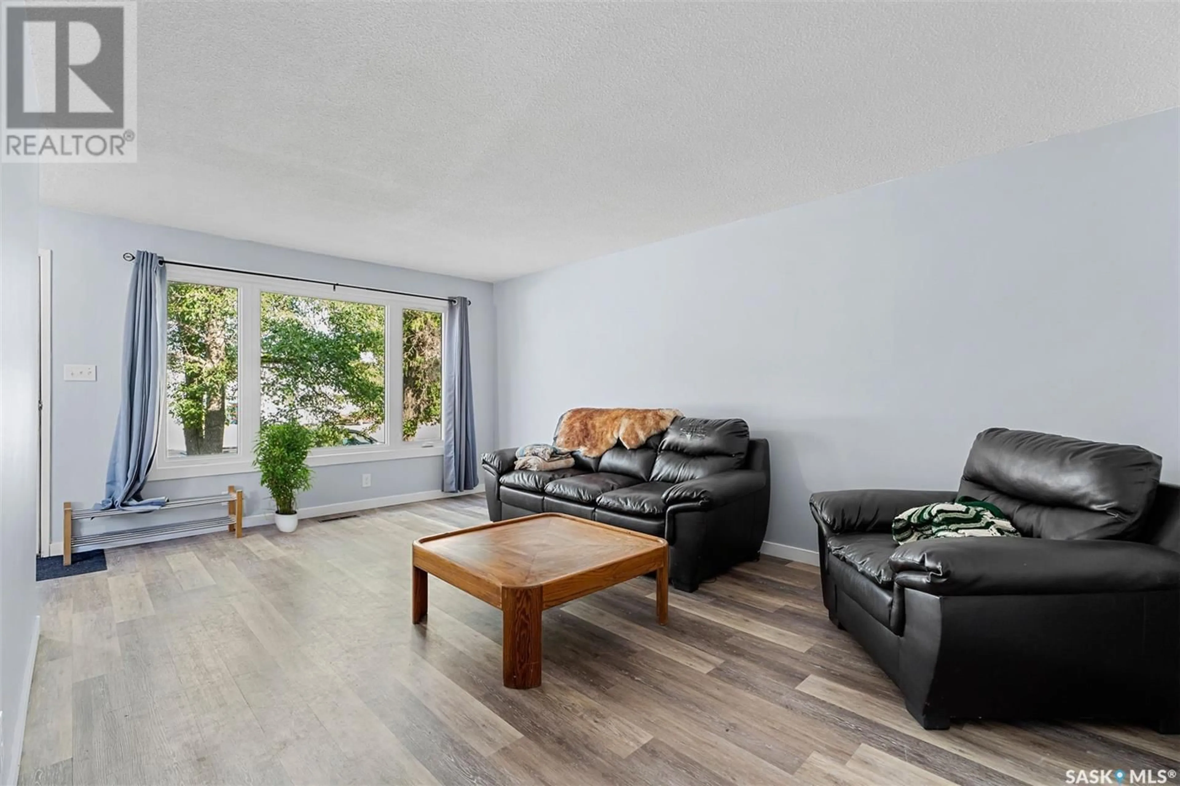Living room with furniture, wood/laminate floor for E - 410 - 412 3RD STREET, Delisle Saskatchewan S0L0P0