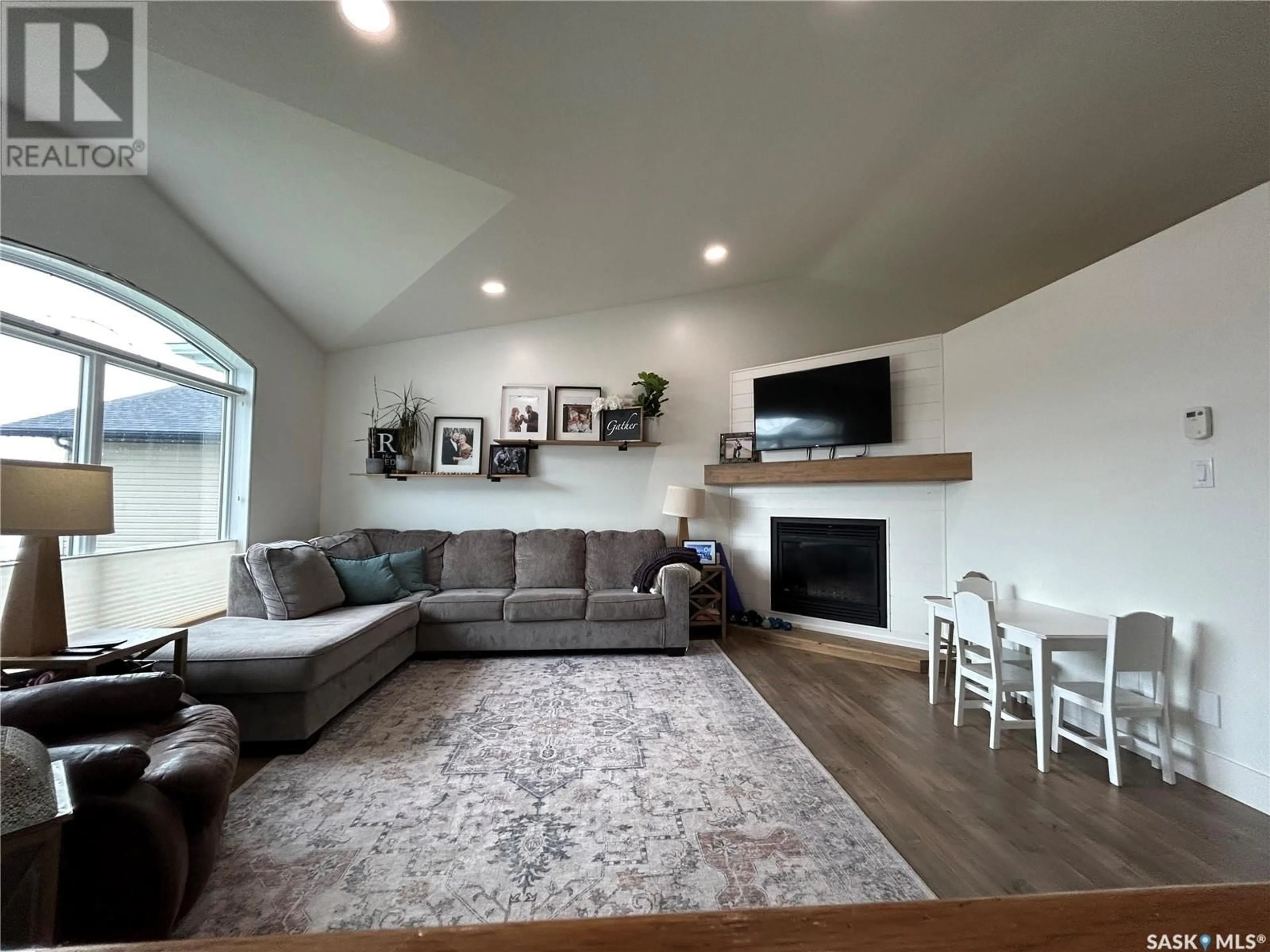 Living room with furniture, wood/laminate floor for 604 FORESTER CRESCENT, Tisdale Saskatchewan S0E1T0