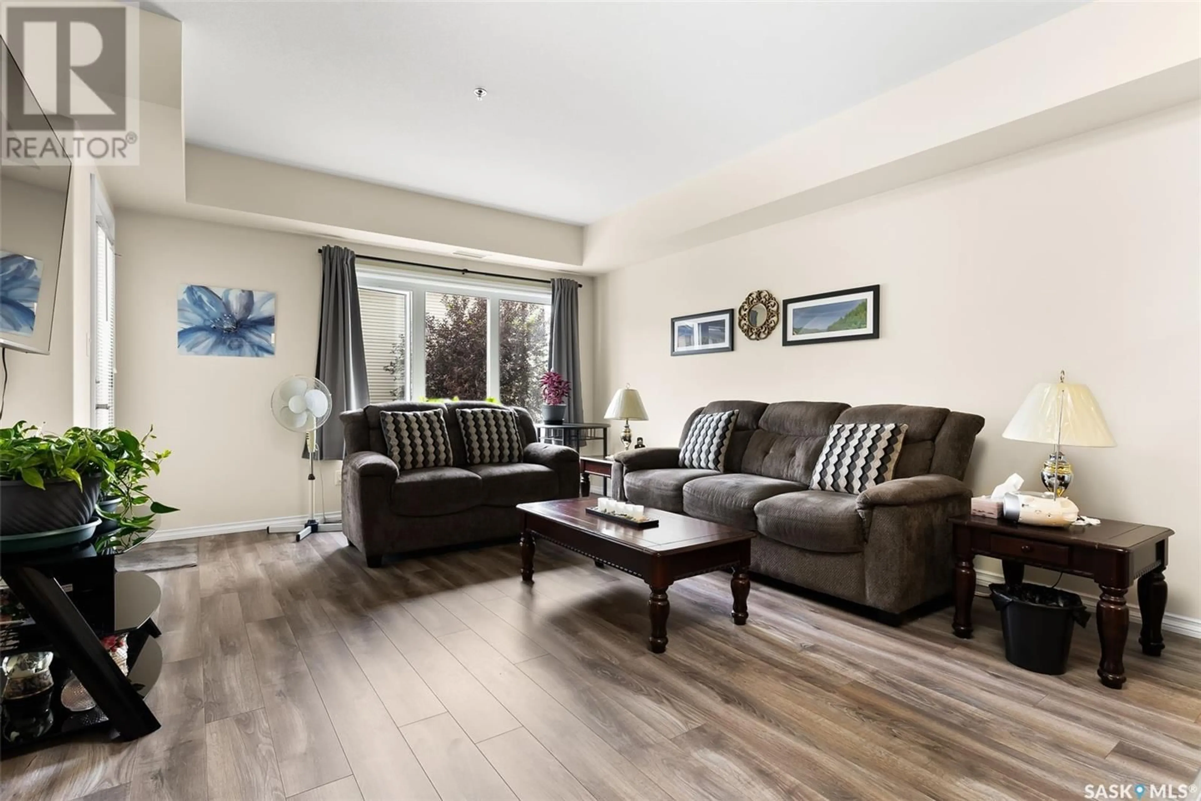 Living room with furniture, wood/laminate floor for 211 - 4501 CHILD AVENUE, Regina Saskatchewan S4X0L7