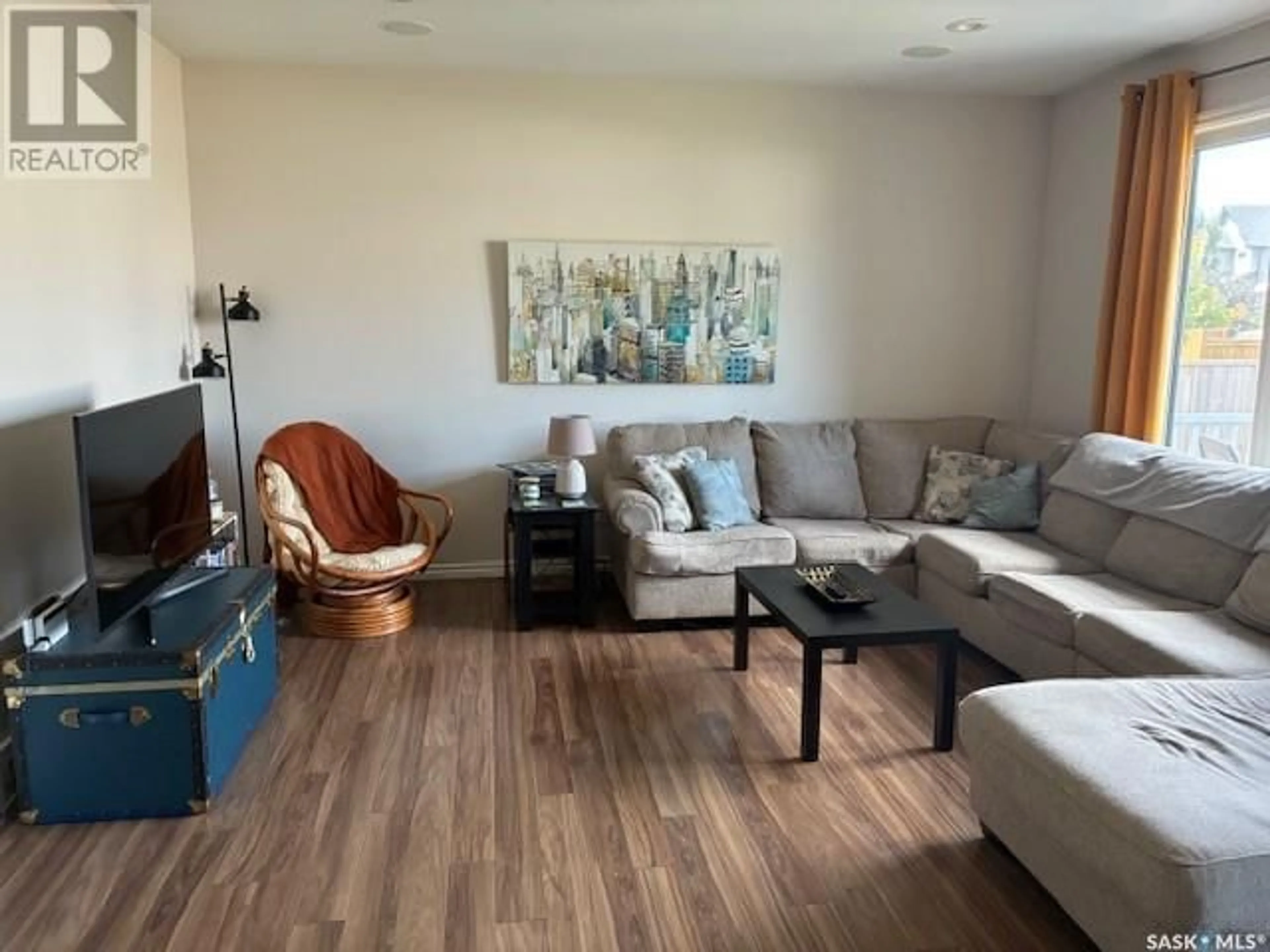 Living room with furniture, wood/laminate floor for 411 LANGLOIS WAY, Saskatoon Saskatchewan S7T0M9