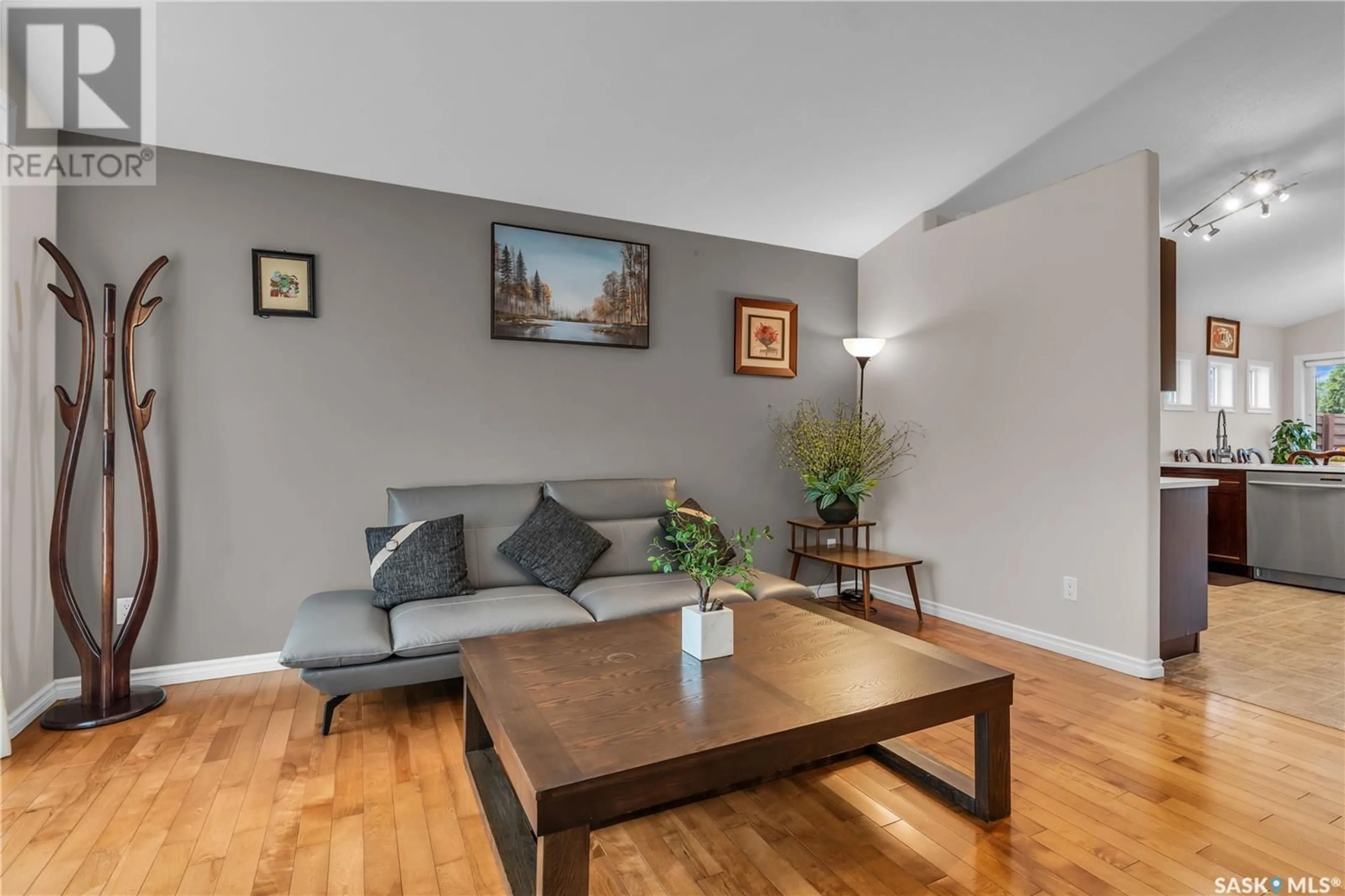 Living room with furniture, wood/laminate floor for 250 ROBERTSON COVE, Saskatoon Saskatchewan S7T0E6