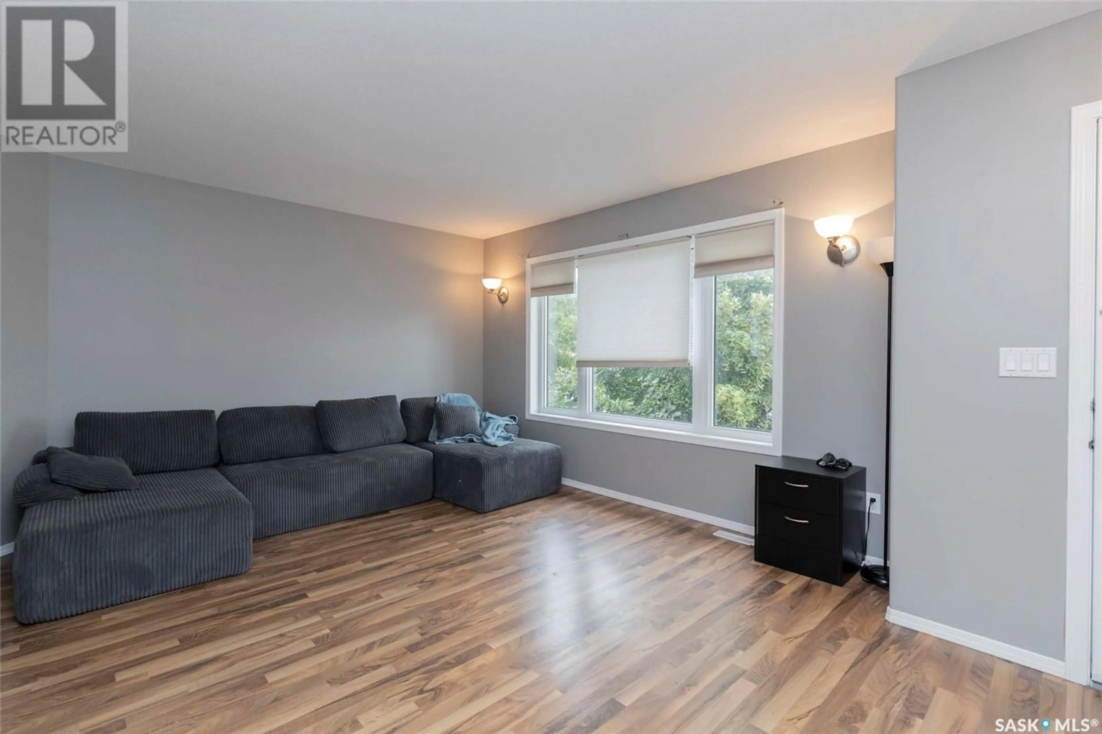 Living room with furniture, wood/laminate floor for 415 GORDON ROAD, Saskatoon Saskatchewan S7T0A1