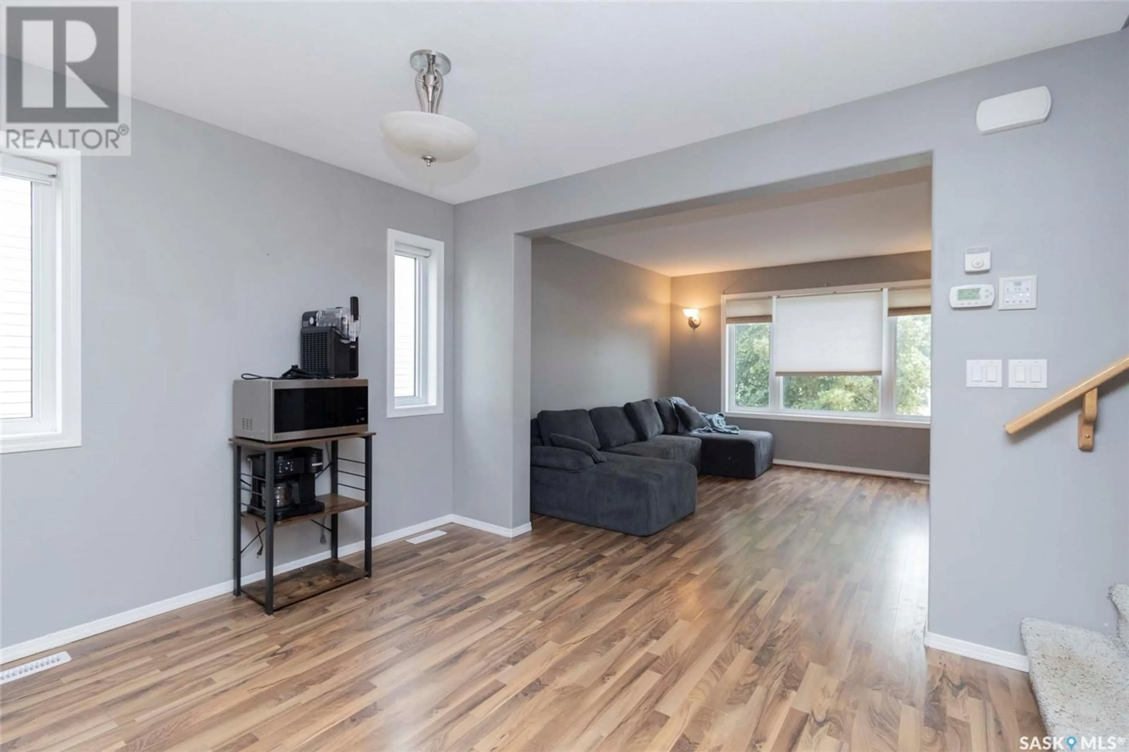 Living room with furniture, wood/laminate floor for 415 GORDON ROAD, Saskatoon Saskatchewan S7T0A1