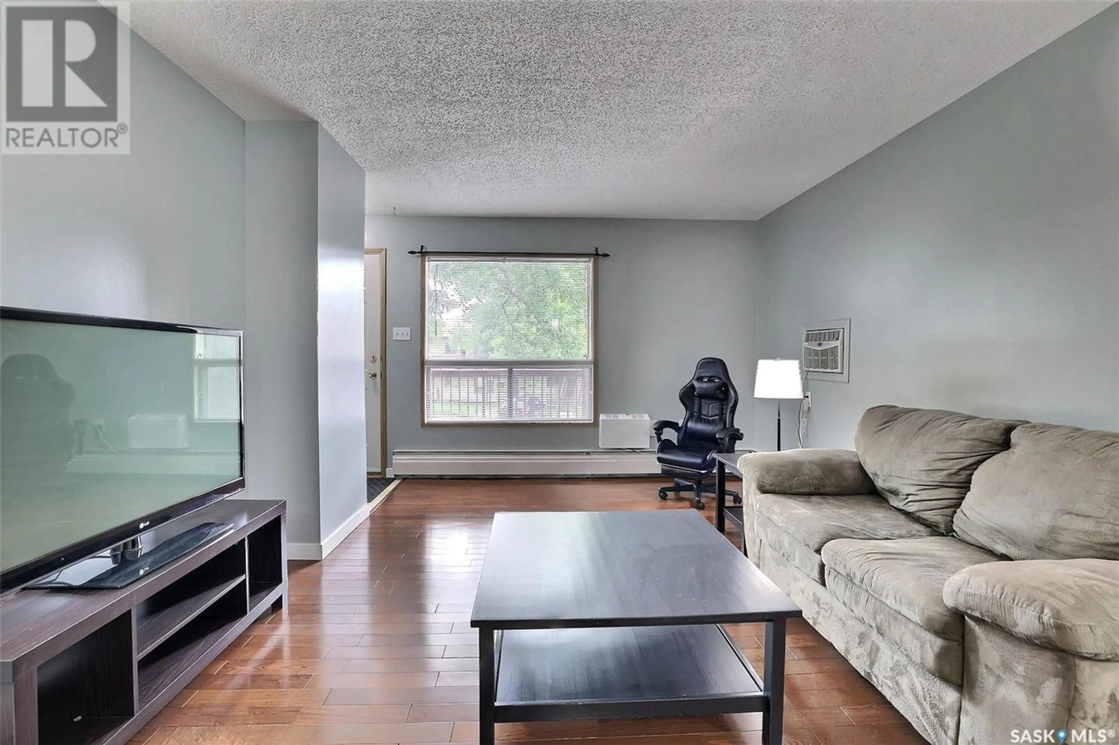 Living room with furniture, wood/laminate floor for 208A - 1350 GORDON ROAD, Moose Jaw Saskatchewan S6H7R9