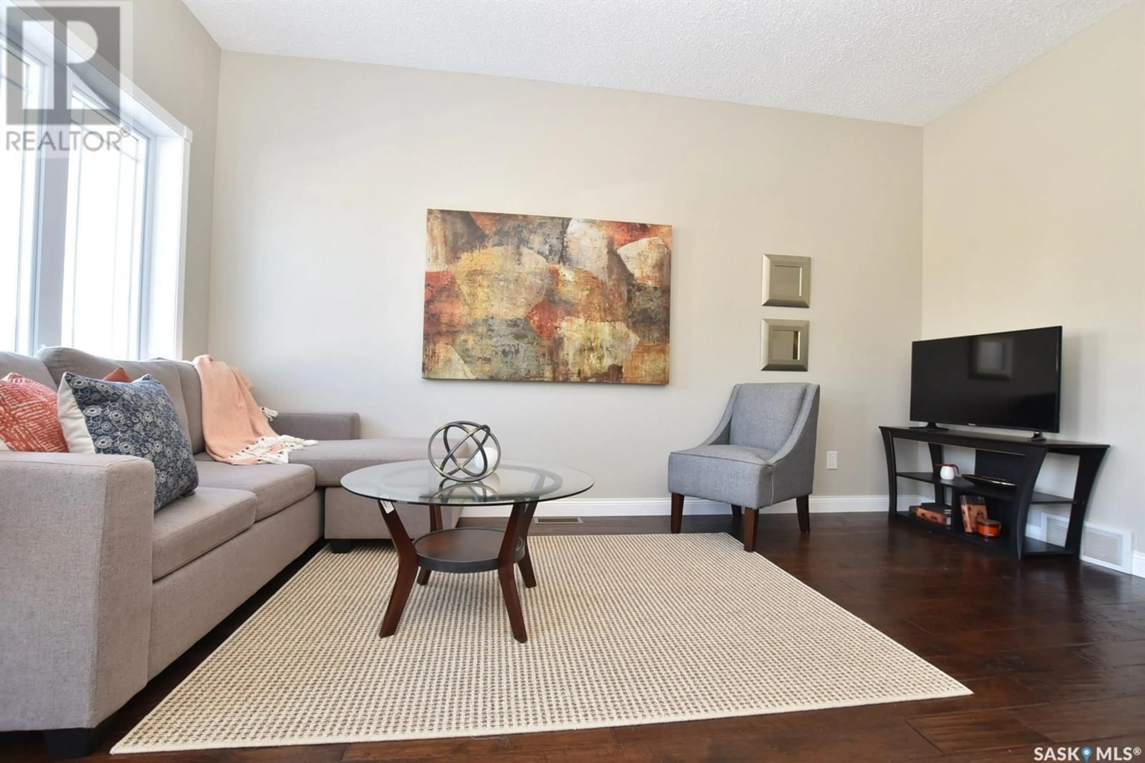Living room with furniture, wood/laminate floor for 34 MCKENZIE LANE, White City Saskatchewan S4L0B2