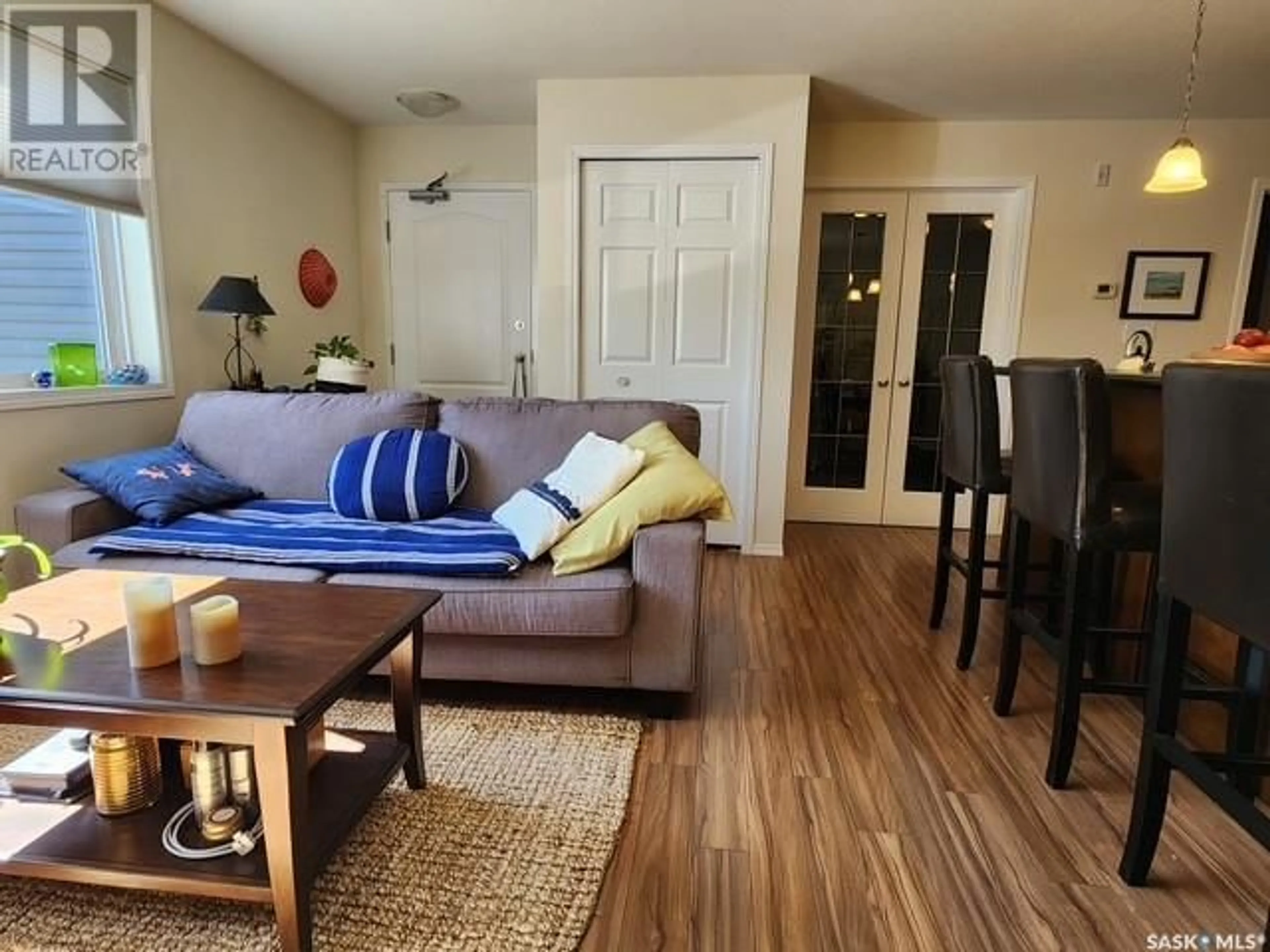 Living room with furniture, wood/laminate floor for 103 - 221 MAIN STREET, Moose Jaw Saskatchewan S6H2R4