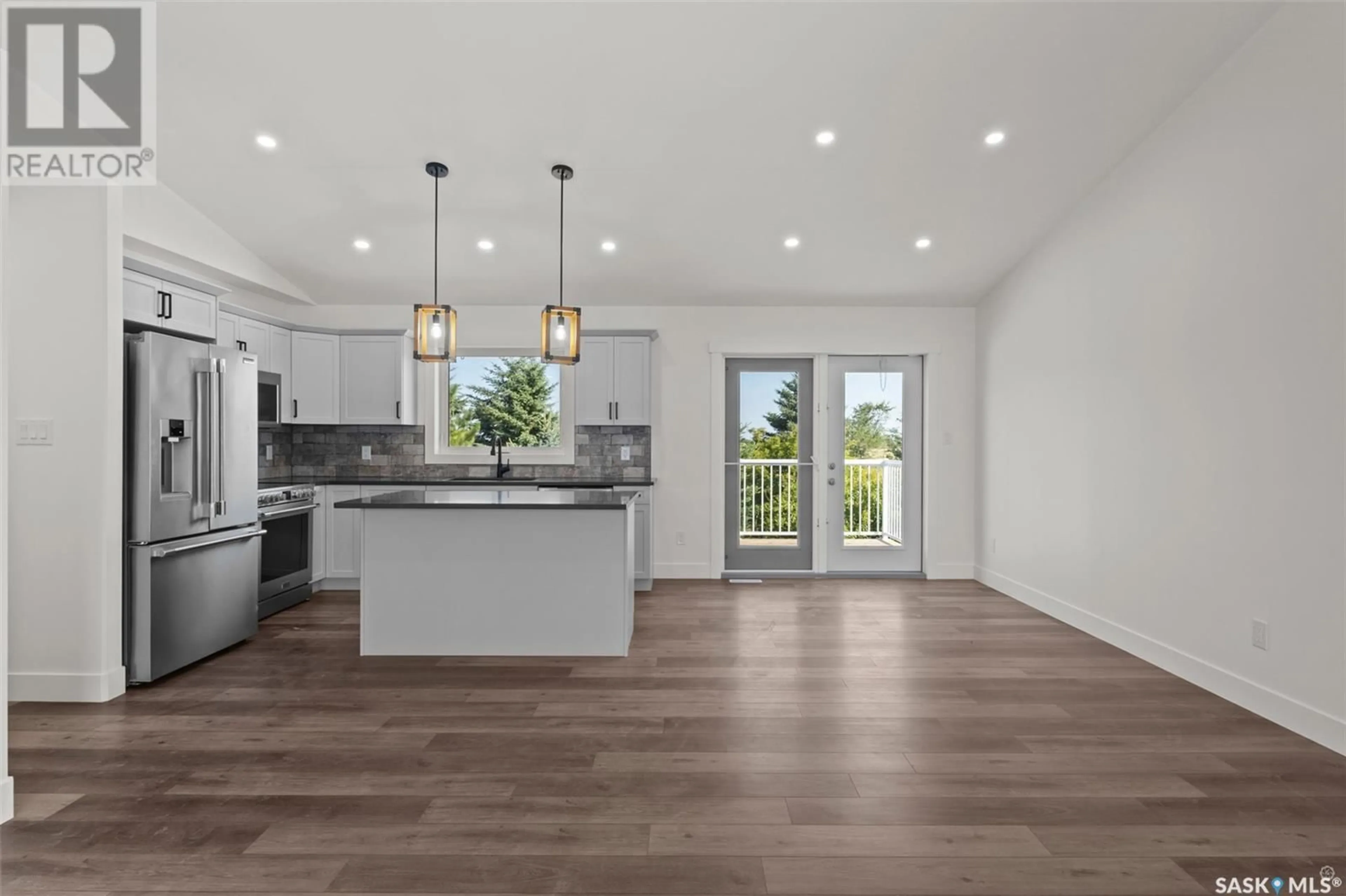 Open concept kitchen, wood/laminate floor for 216 KESTREL COURT, Rosthern Saskatchewan S0K3R0