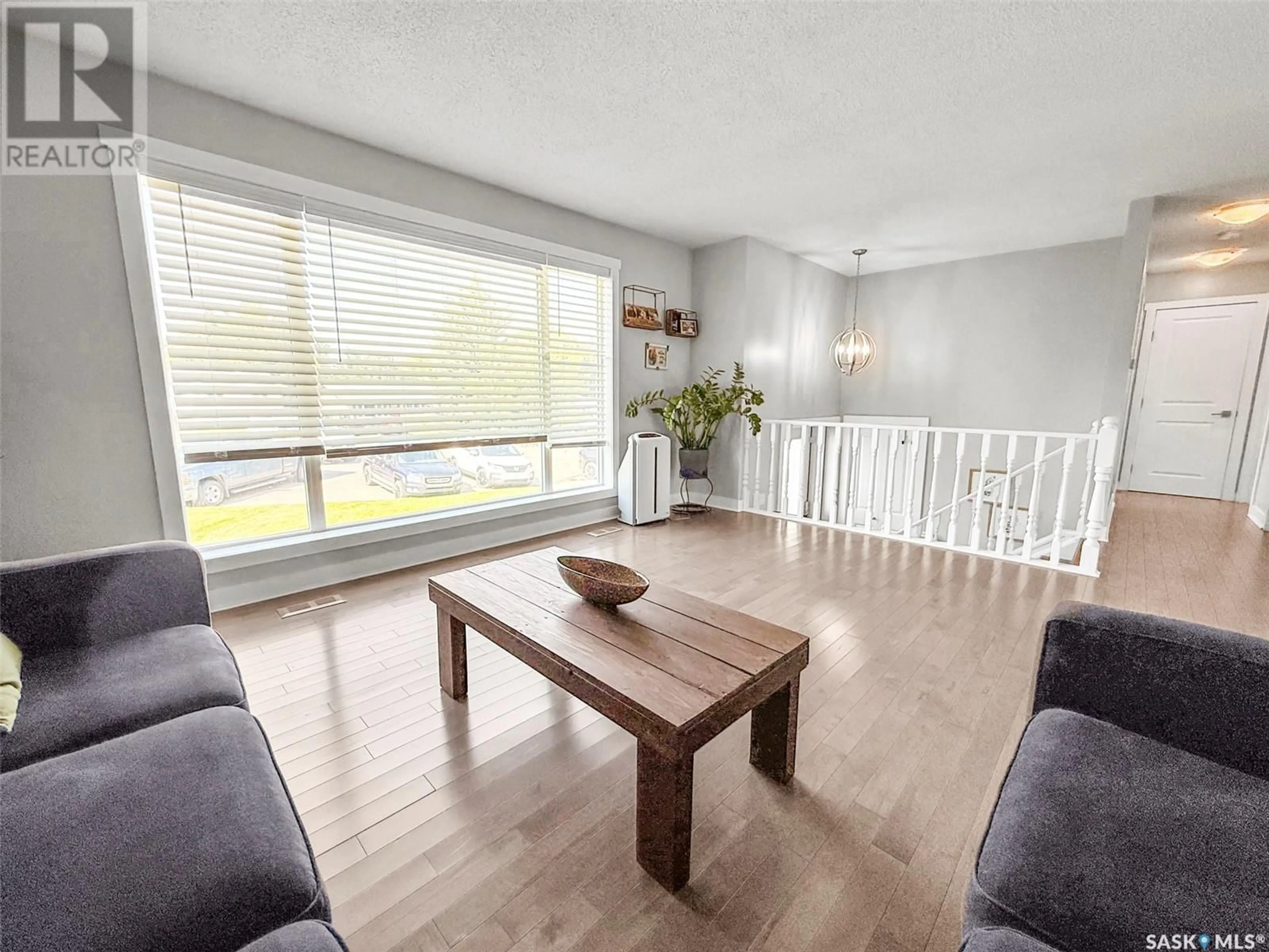 Living room with furniture, wood/laminate floor for 212 CLINTON PLACE, Swift Current Saskatchewan S9H4K2