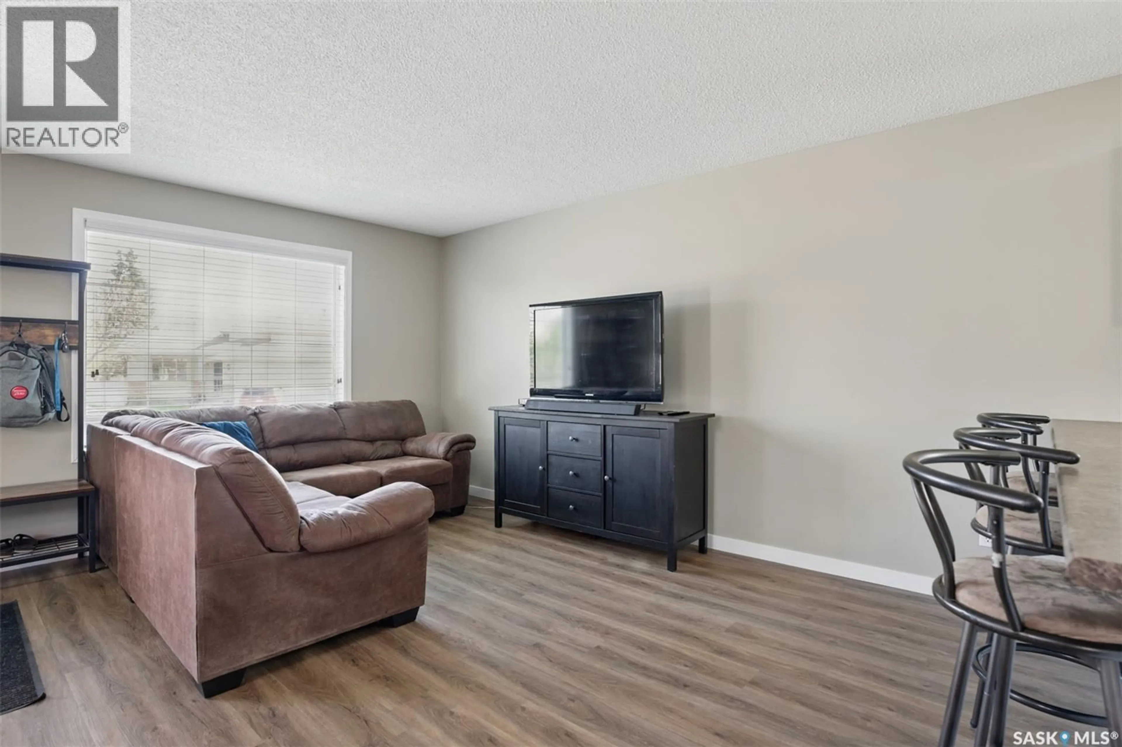 Living room with furniture, wood/laminate floor for 303 NIXON CRESCENT, Saskatoon Saskatchewan S7L7G1