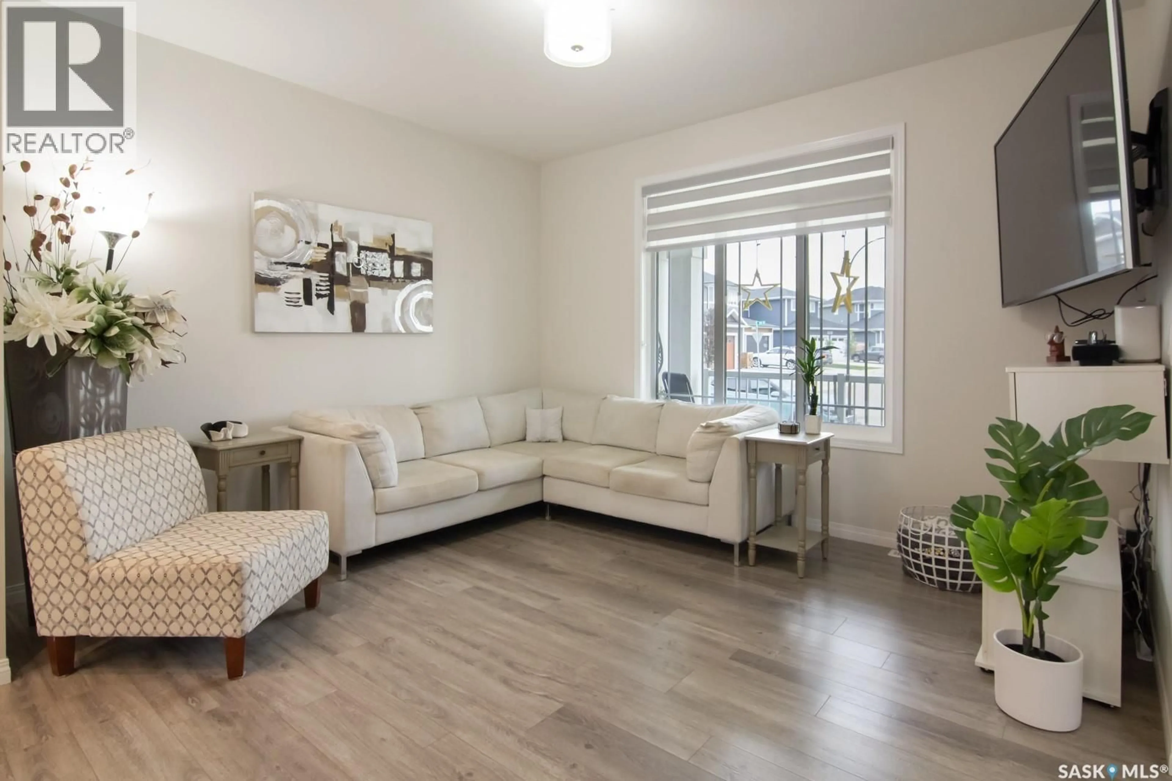 Living room with furniture, wood/laminate floor for 152 DUBOIS CRESCENT, Saskatoon Saskatchewan S7V0R5