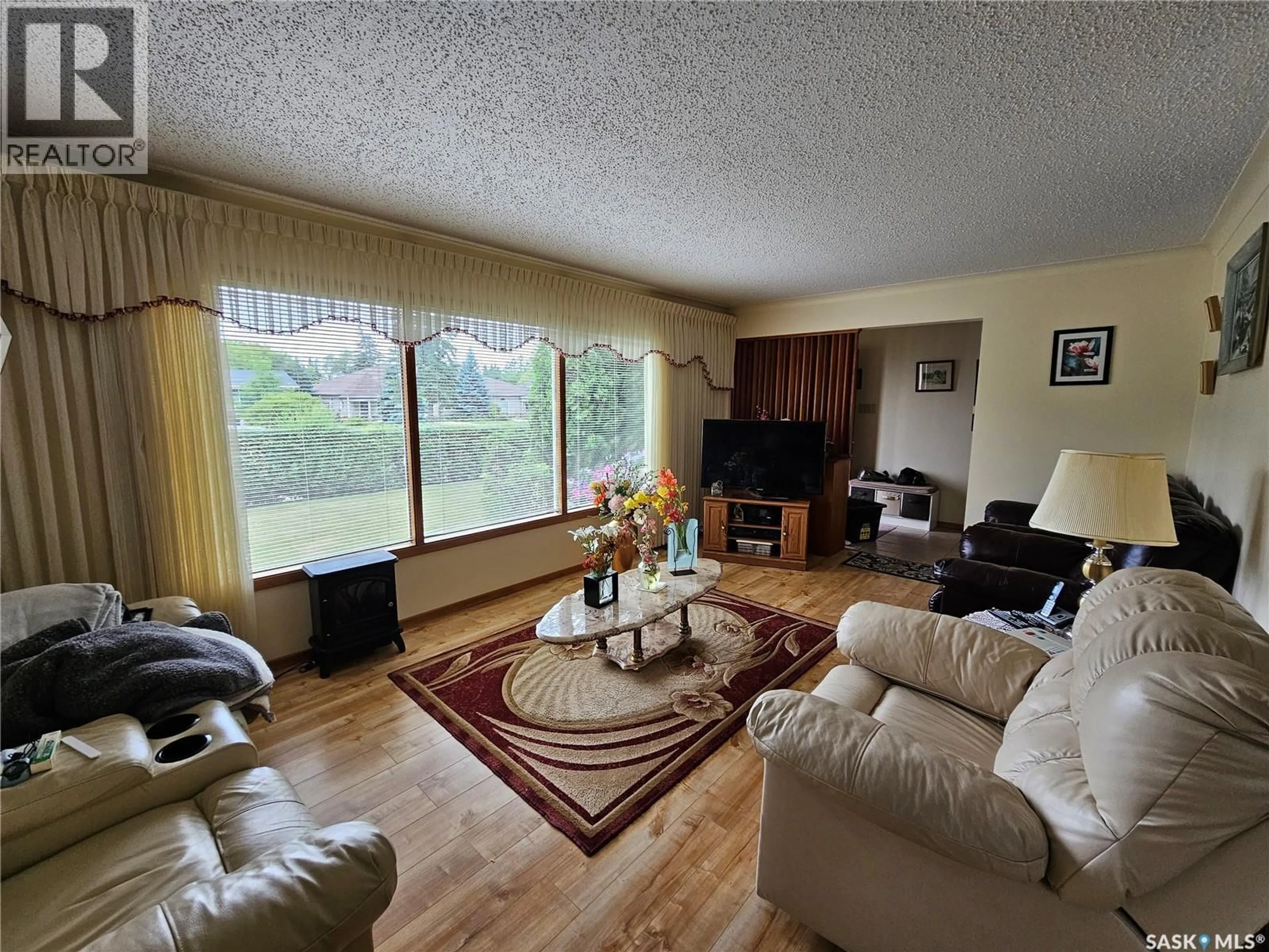 Living room with furniture, wood/laminate floor for 605 CENTRE STREET, Meadow Lake Saskatchewan S9X1E9