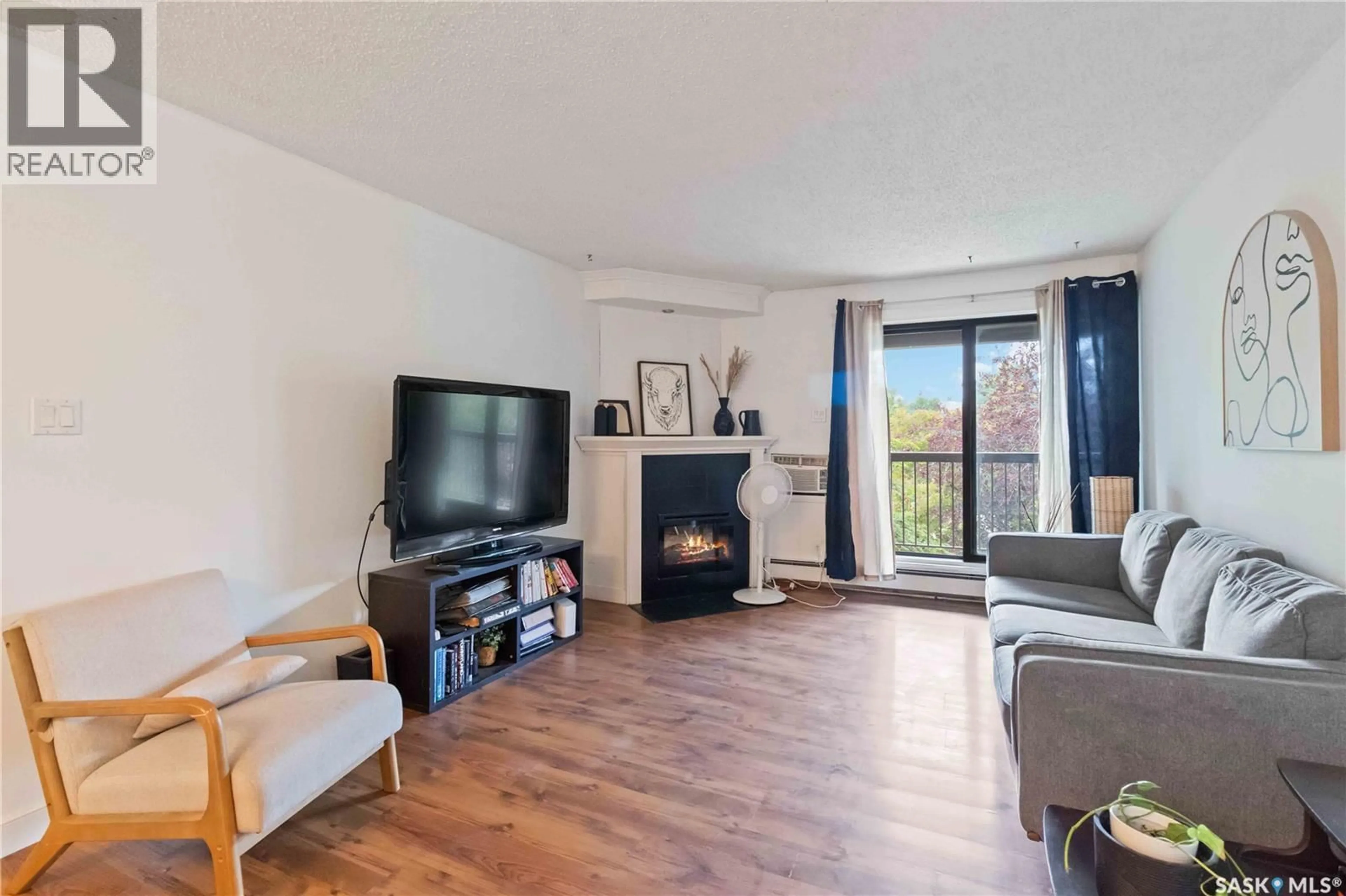 Living room with furniture, wood/laminate floor for 305 - 302 KINGSMERE BOULEVARD, Saskatoon Saskatchewan S7J4J6