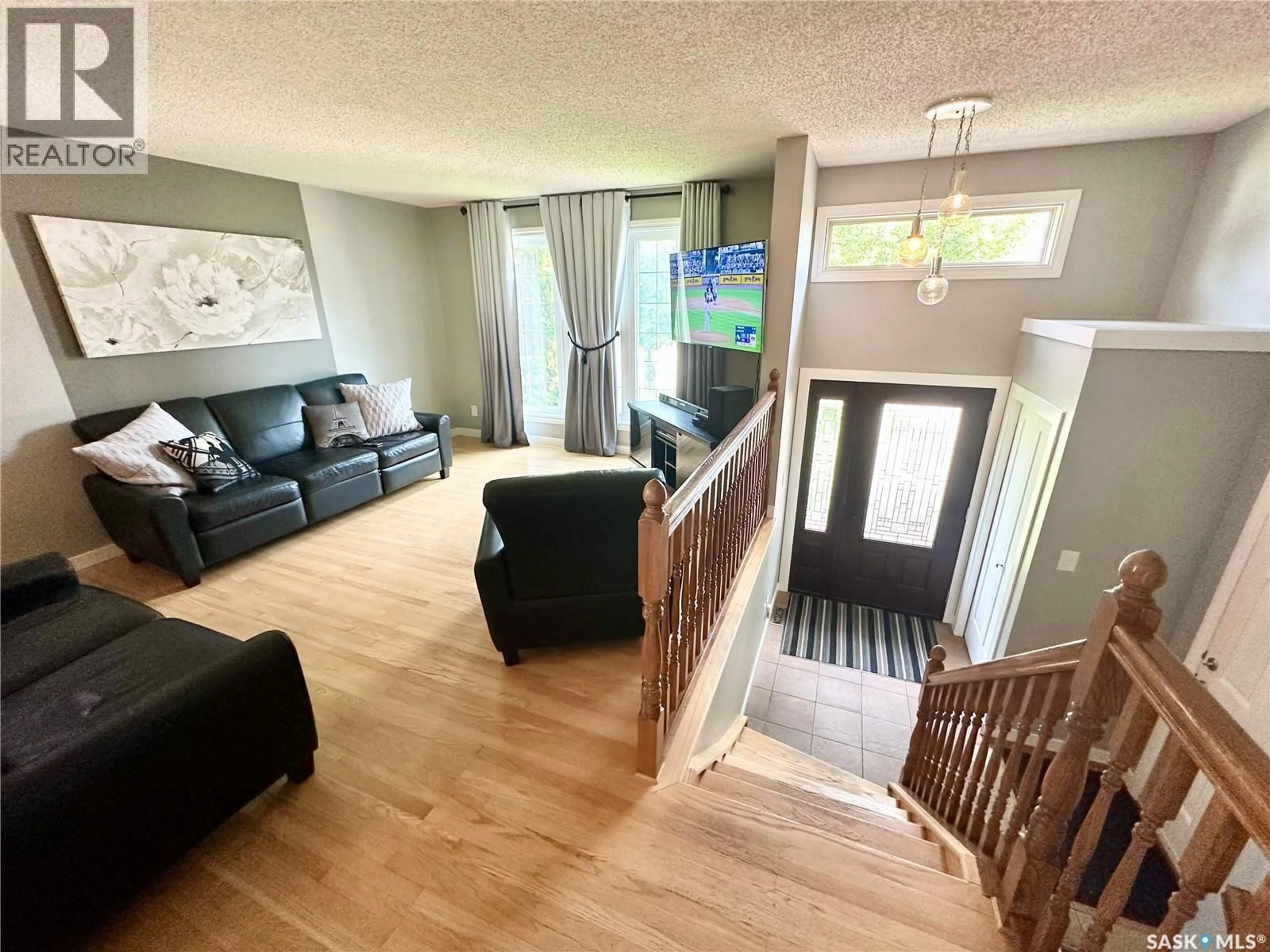 Living room with furniture, wood/laminate floor for 110 BRONSON CRESCENT, Saskatoon Saskatchewan S7J5C8