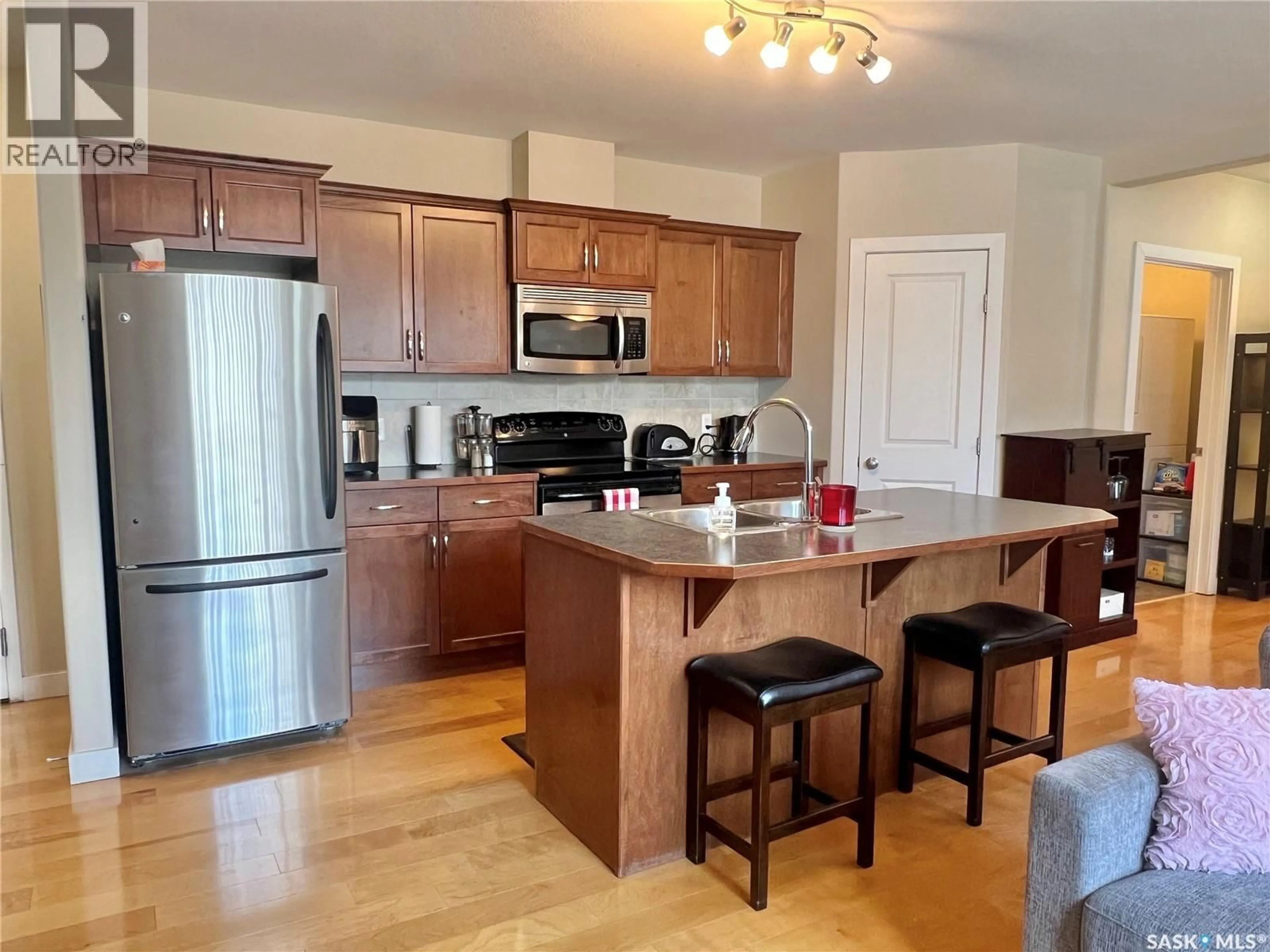 Open concept kitchen, wood/laminate floor for 302 - 114 BEMISTER AVENUE E, Melfort Saskatchewan S0E1A0