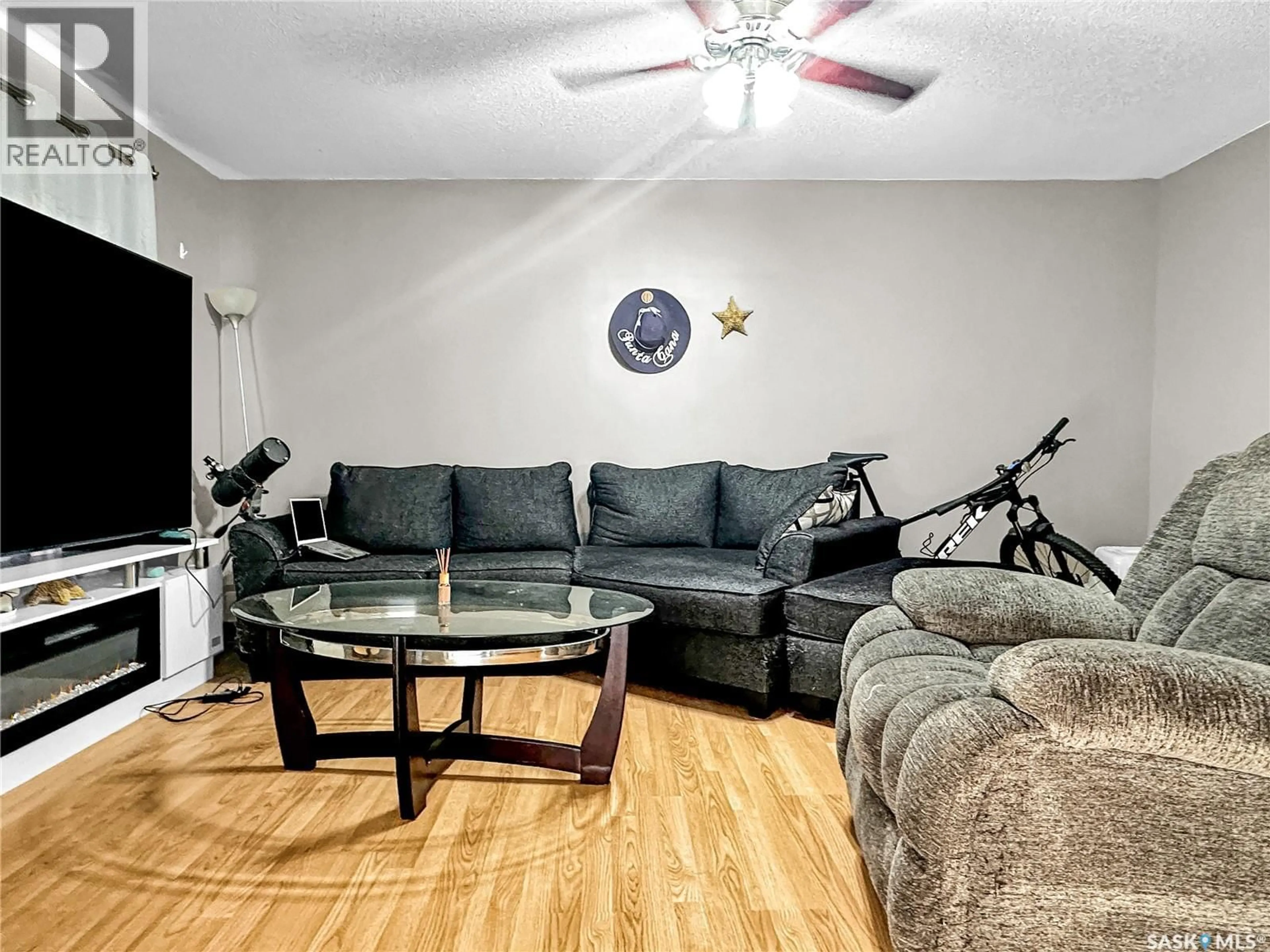 Living room with furniture, wood/laminate floor for 521 103RD STREET, North Battleford Saskatchewan S9A1J6