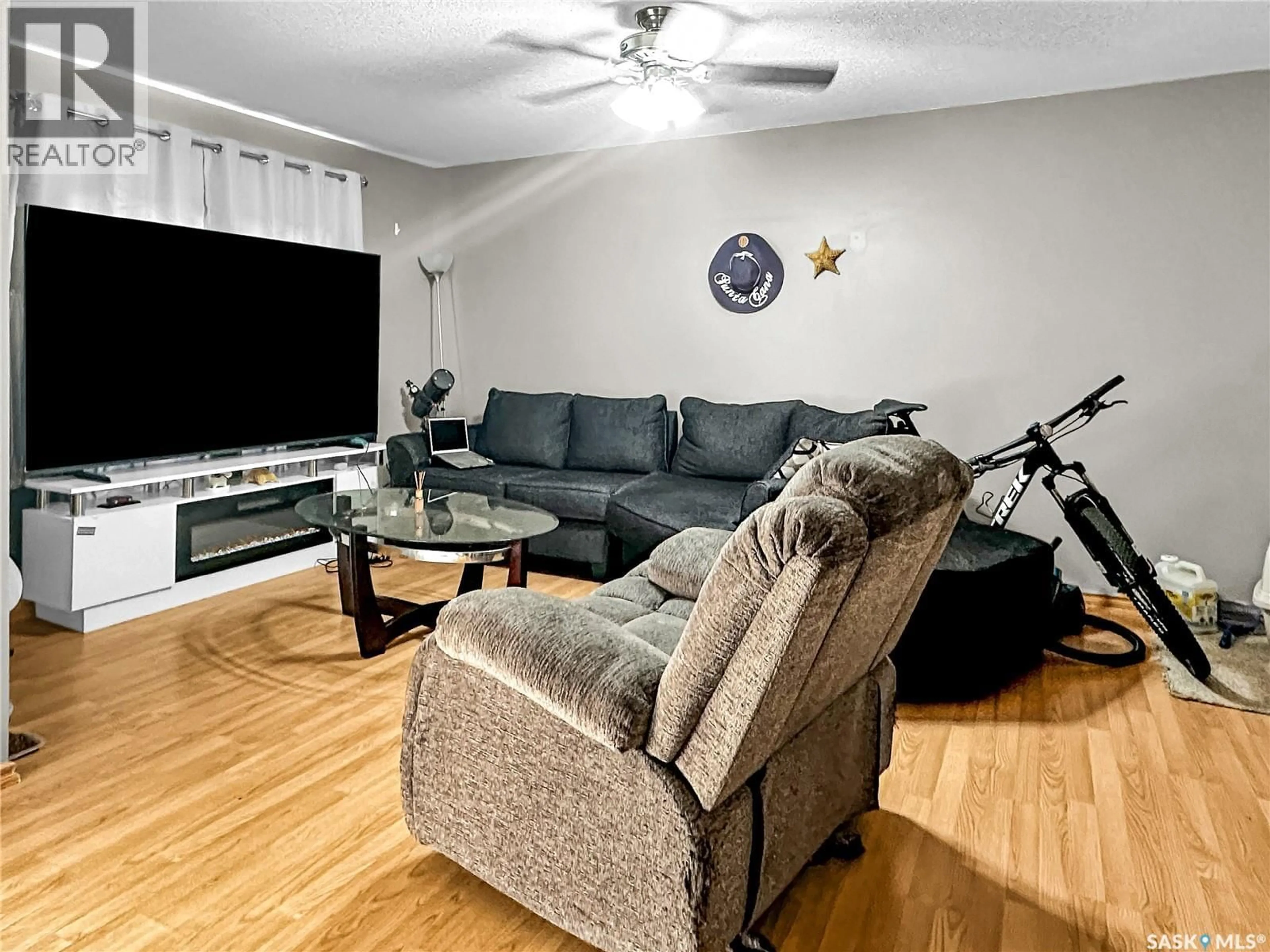 Living room with furniture, wood/laminate floor for 521 103RD STREET, North Battleford Saskatchewan S9A1J6
