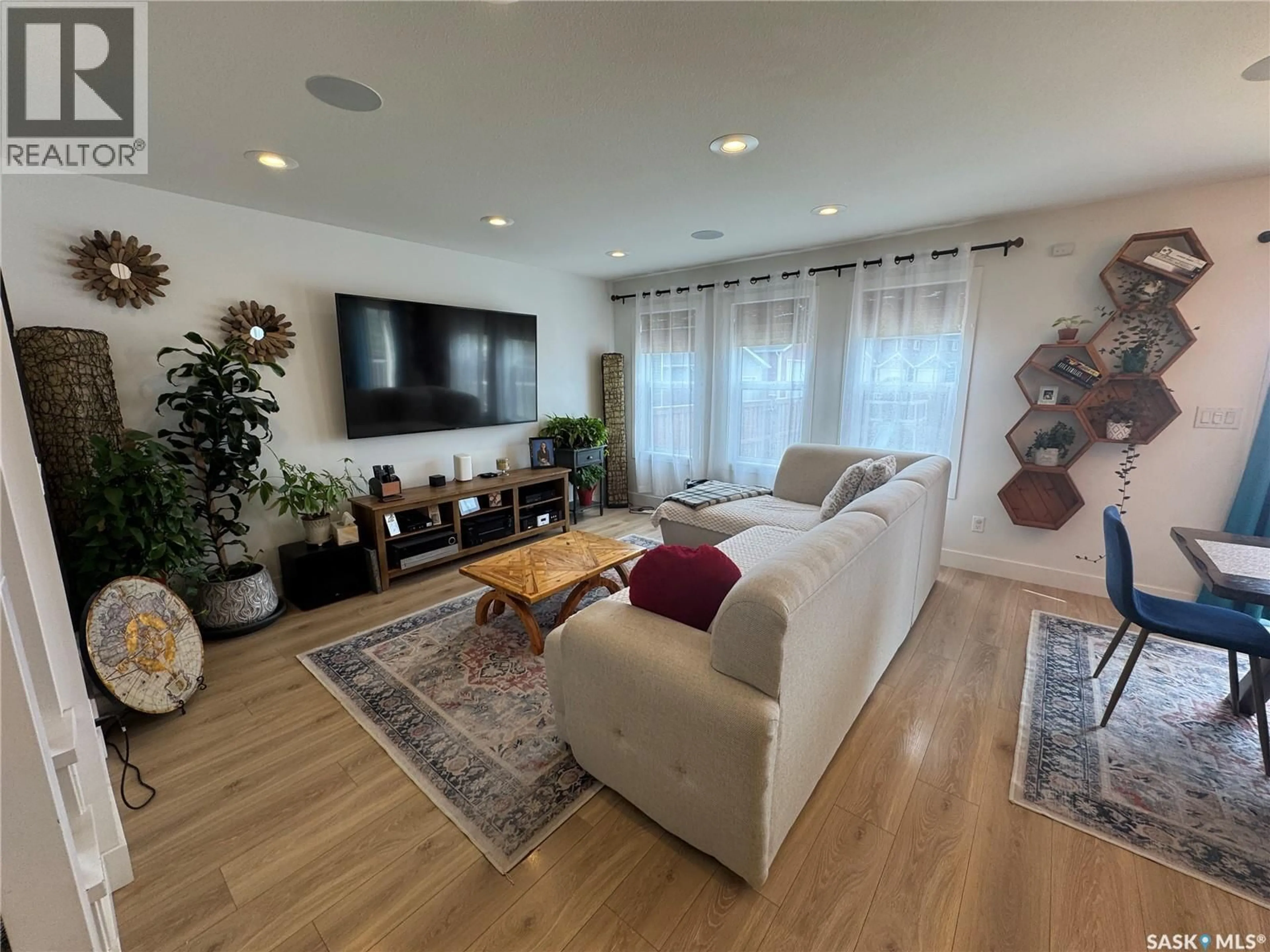 Living room with furniture, wood/laminate floor for 103 STROMBERG CRESCENT, Saskatoon Saskatchewan S7L7C4