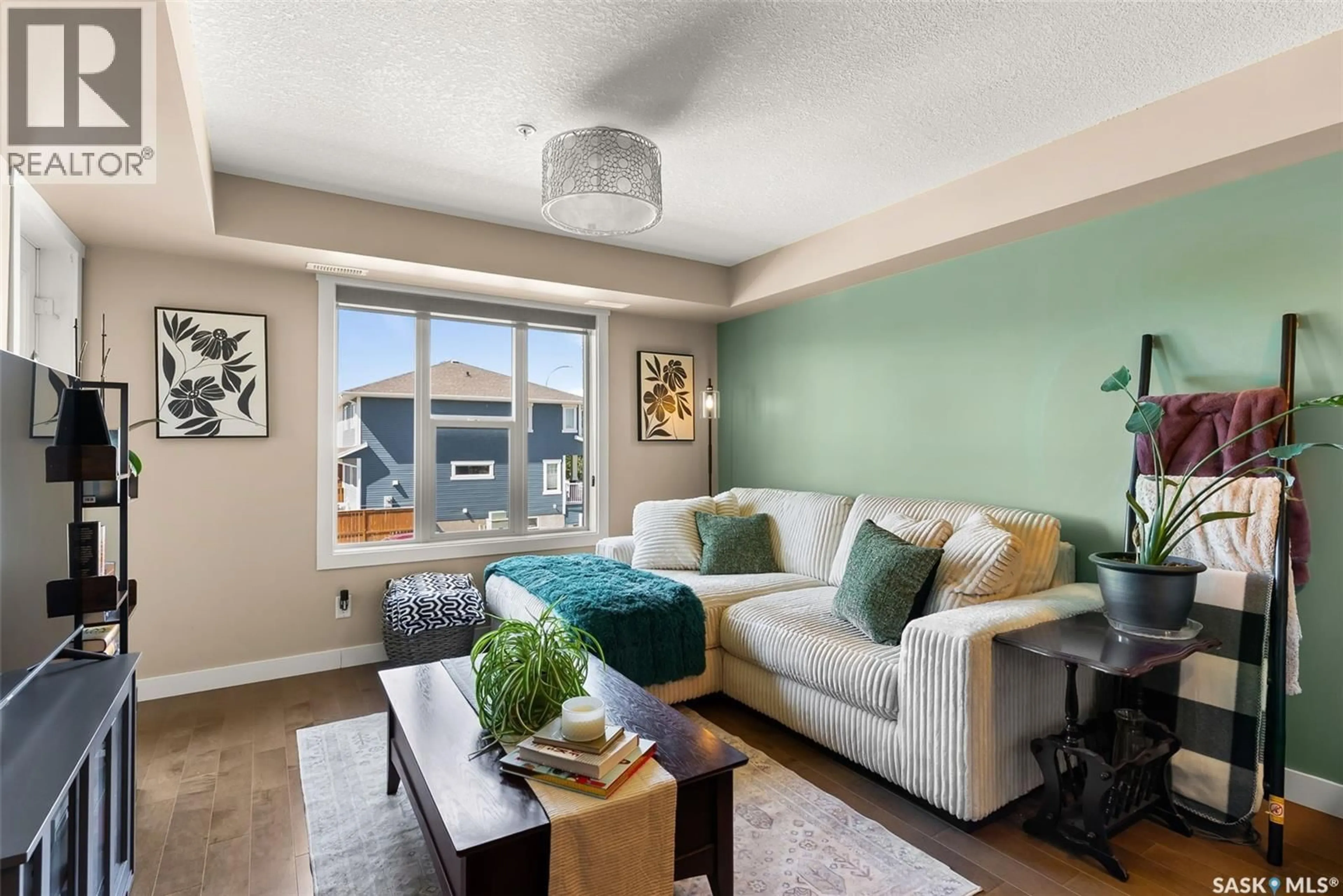 Living room with furniture, wood/laminate floor for 211 - 5301 UNIVERSAL CRESCENT, Regina Saskatchewan S4W0L2