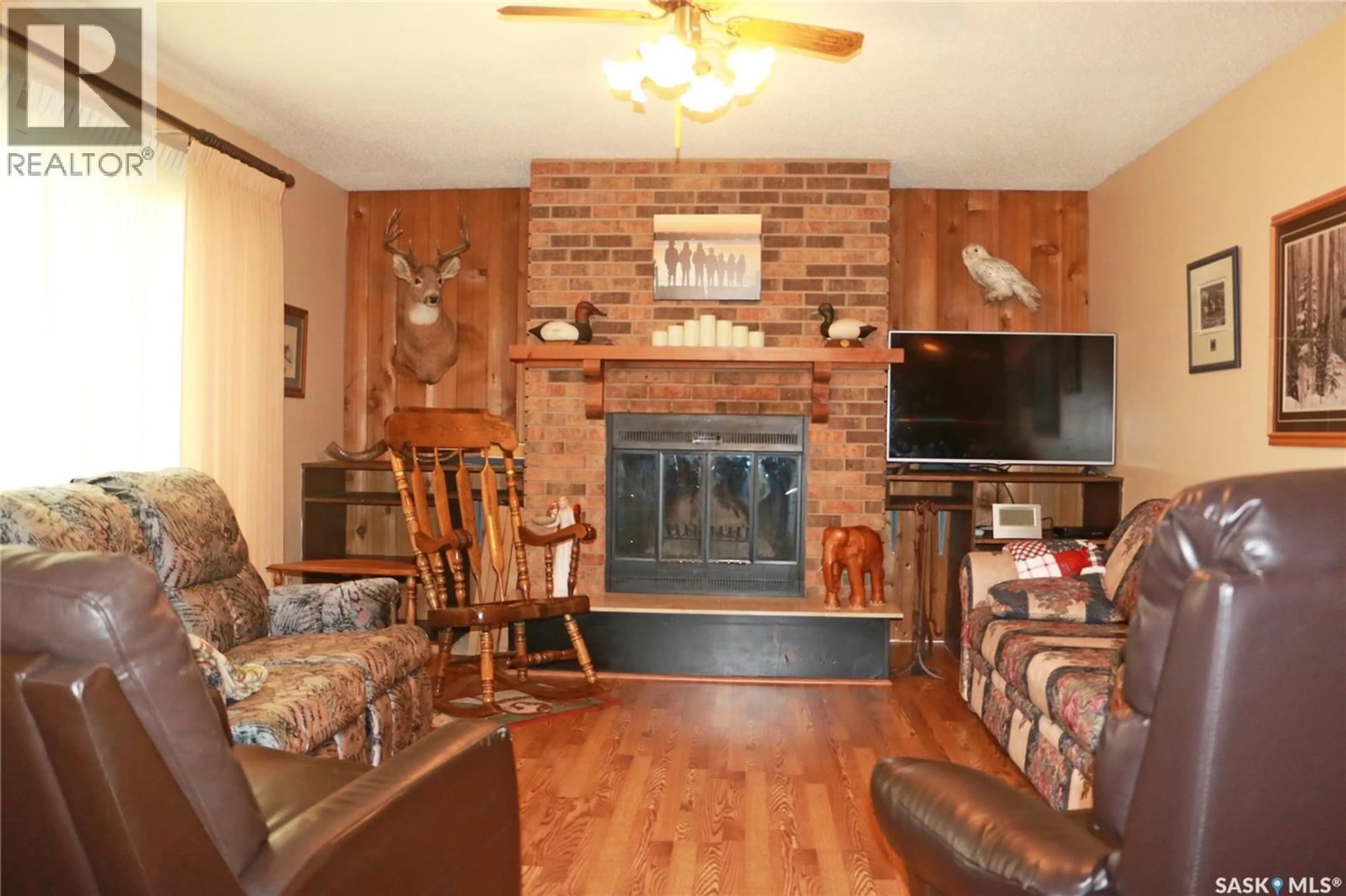 Living room with furniture, wood/laminate floor for 32 HOWARD CRESCENT, Lanigan Saskatchewan S0K2M0