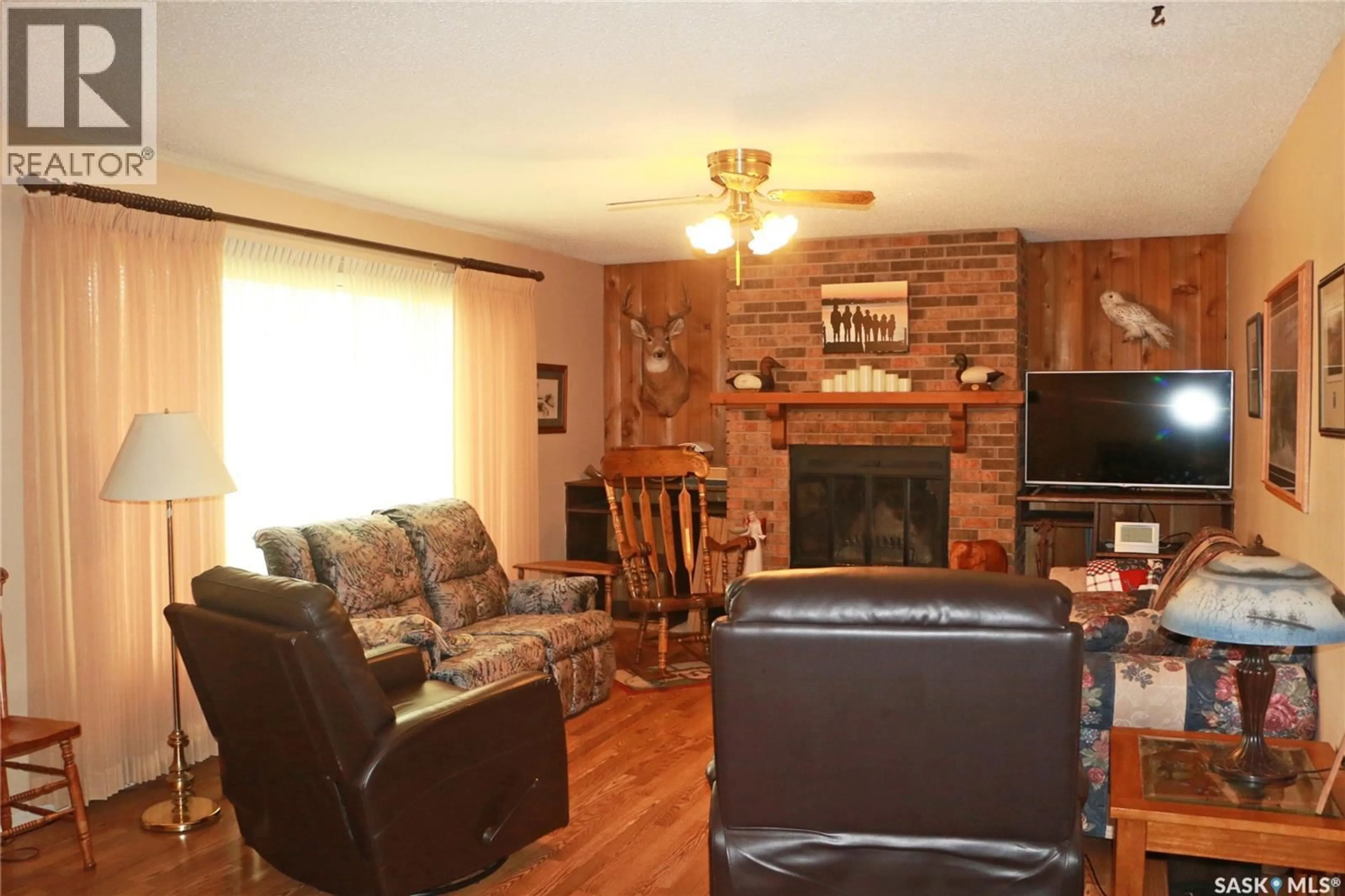 Living room with furniture, wood/laminate floor for 32 HOWARD CRESCENT, Lanigan Saskatchewan S0K2M0