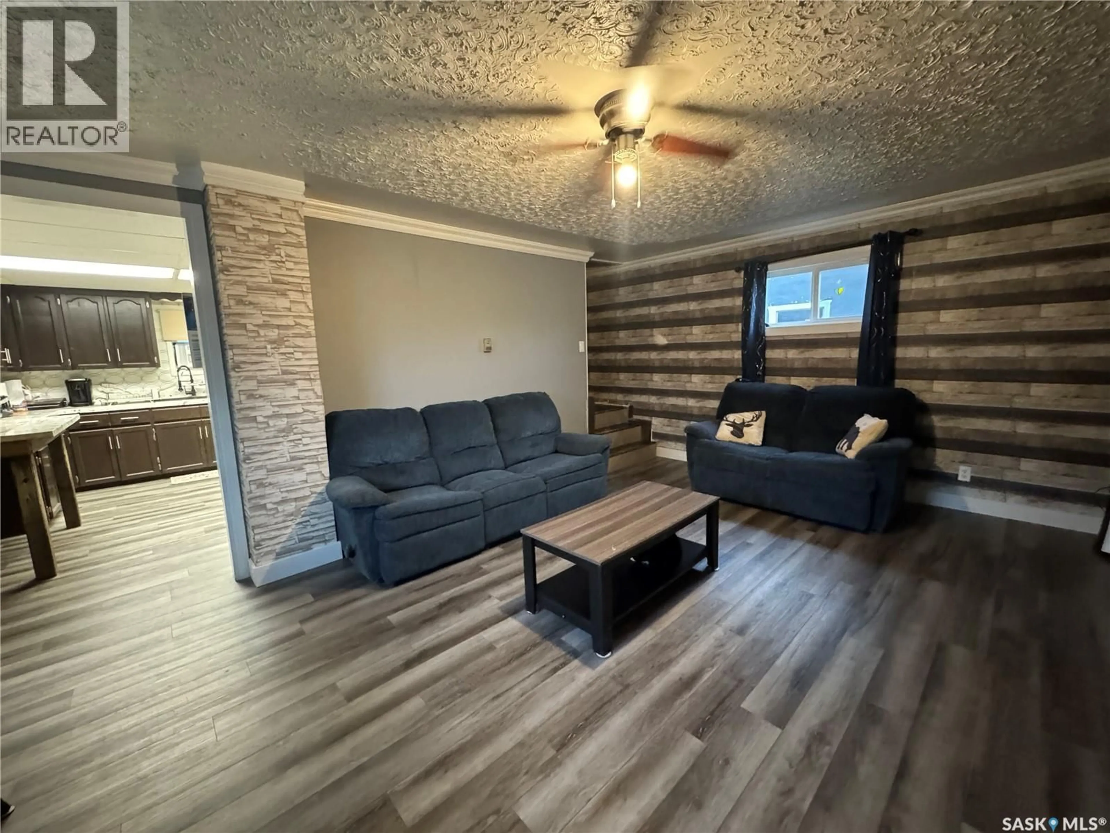 Living room with furniture, wood/laminate floor for 414 3RD AVENUE, Biggar Saskatchewan S0K0M0