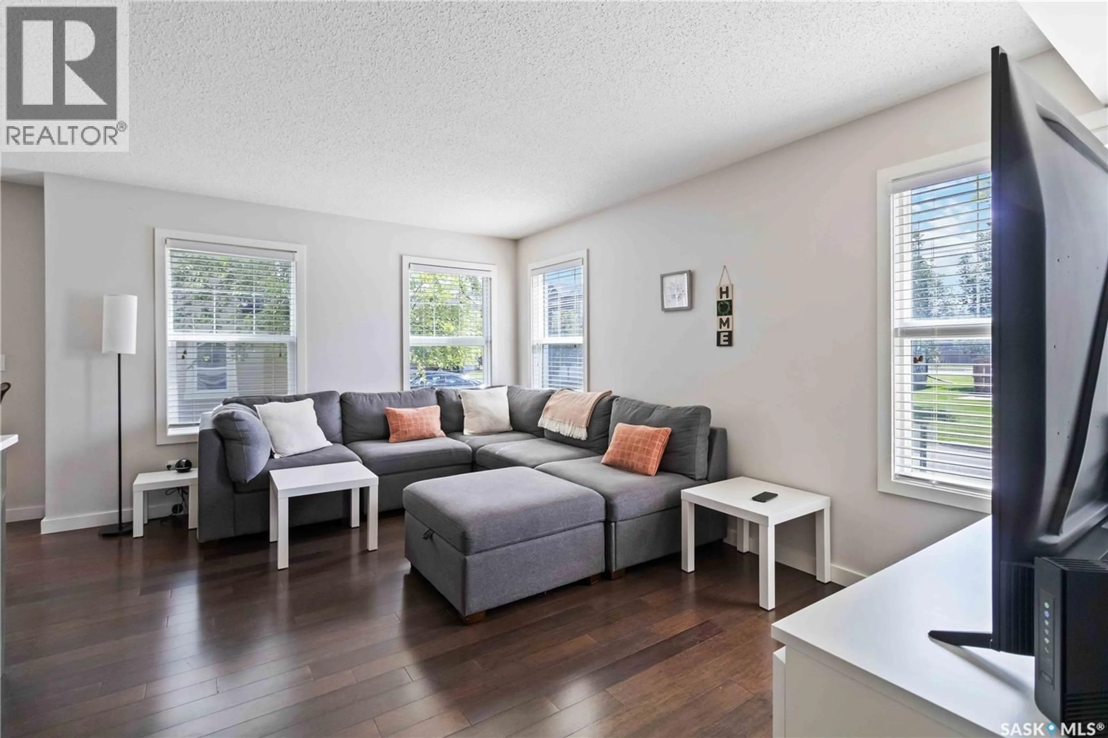 Living room with furniture, wood/laminate floor for 205 - 410 LEDINGHAM WAY, Saskatoon Saskatchewan S7V0C4