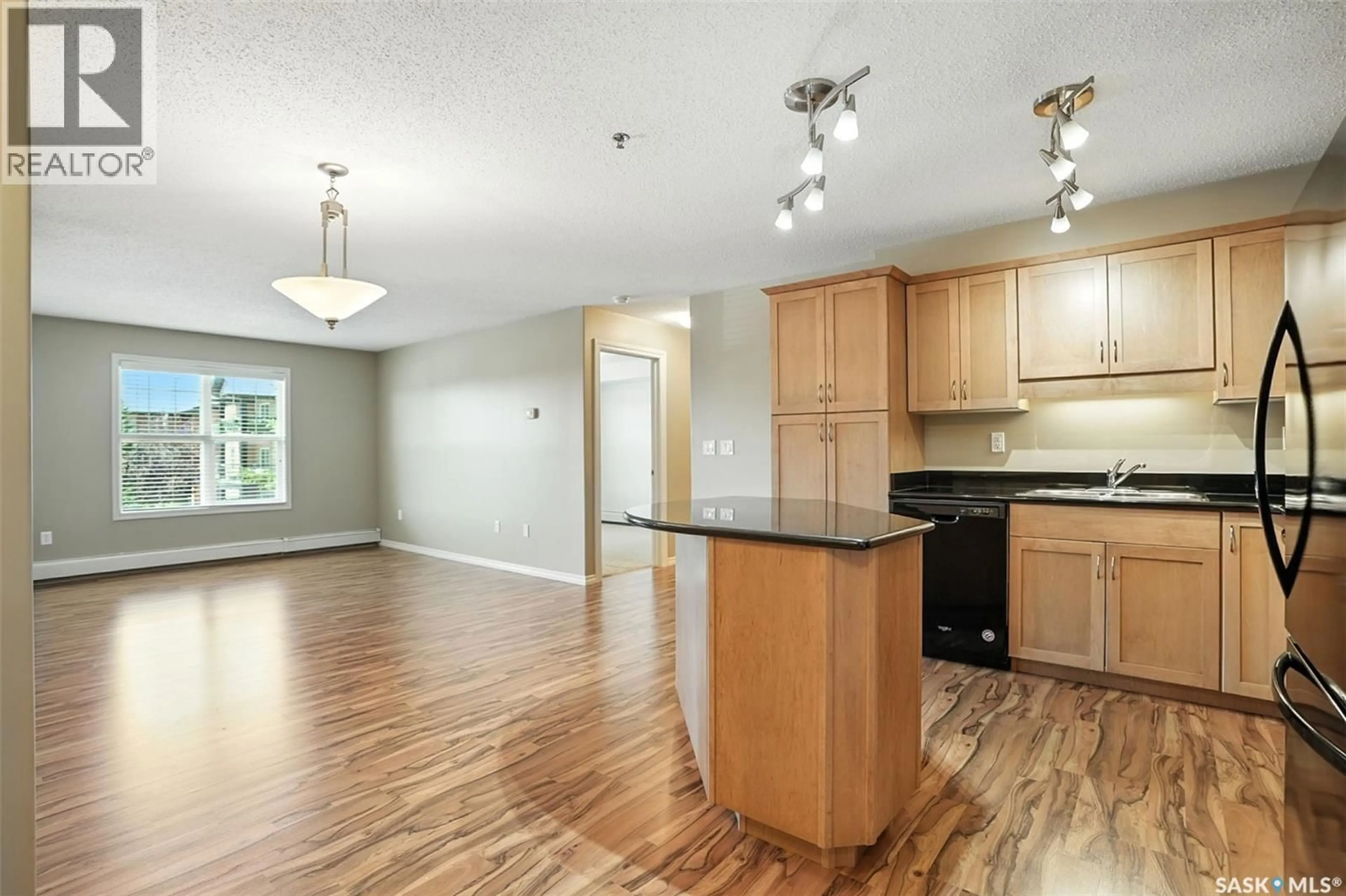 Open concept kitchen, wood/laminate floor for 215B 103 WELLMAN CRESCENT, Saskatoon Saskatchewan S7T0C1