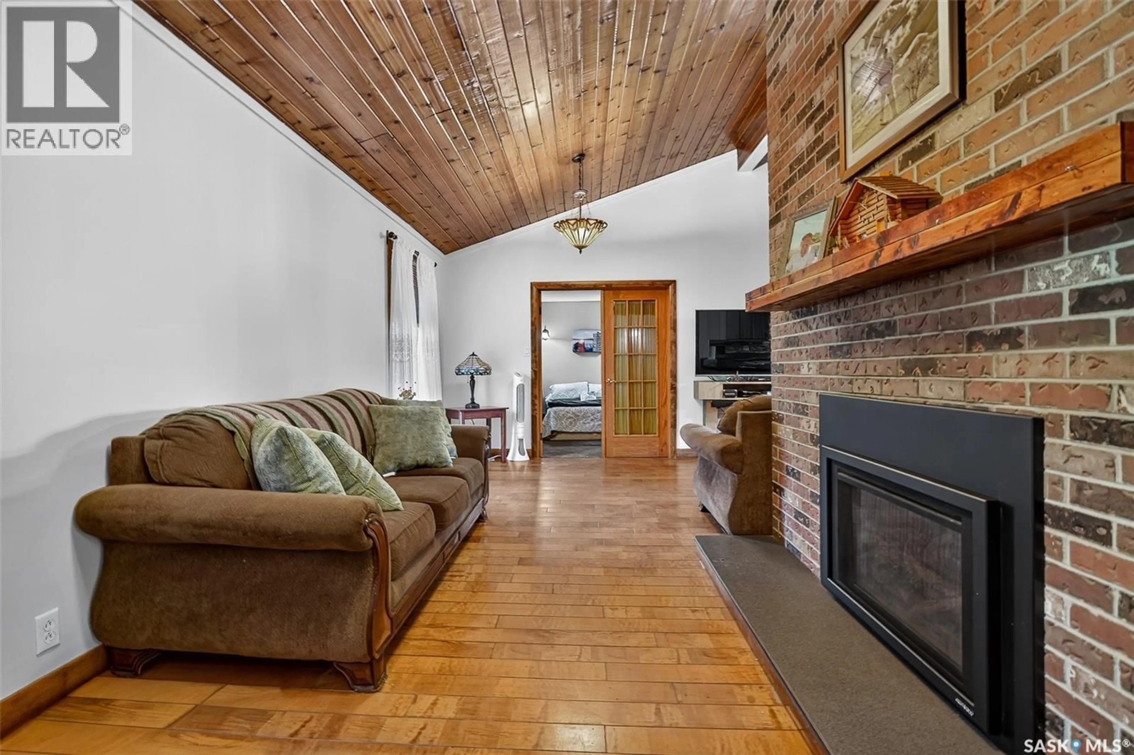 Living room with furniture, wood/laminate floor for 217 PARKVIEW ROAD, Marquis Rm No. 191 Saskatchewan S0H2X0