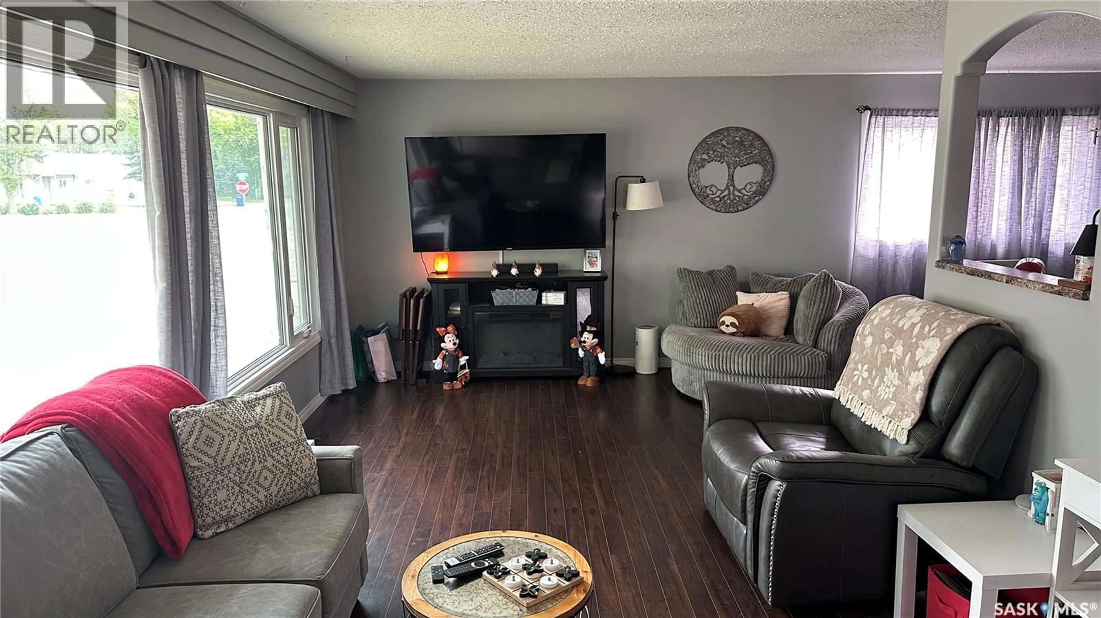 Living room with furniture, wood/laminate floor for 1010 105TH AVENUE, Tisdale Saskatchewan S0E1T0