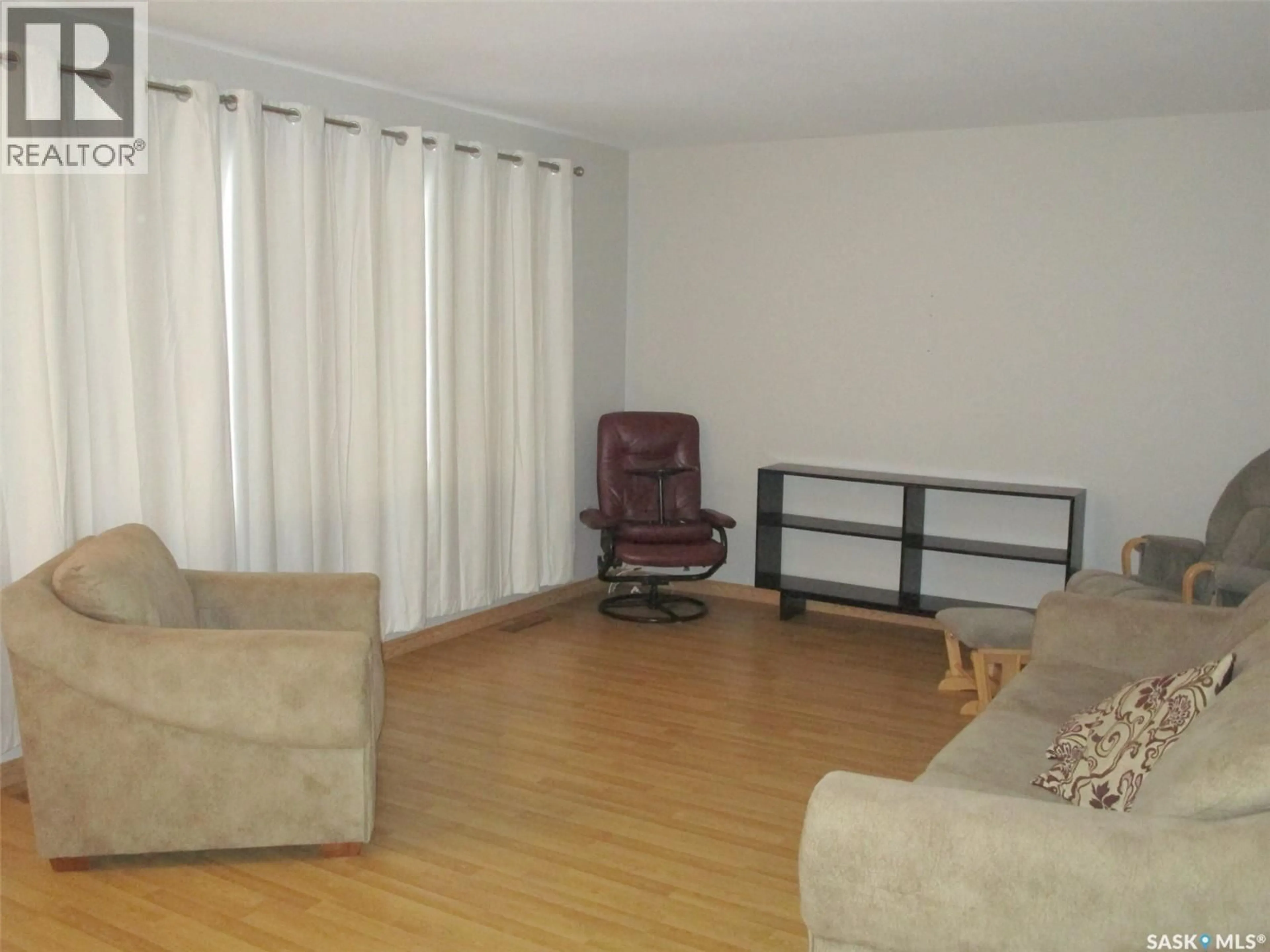 Living room with furniture, wood/laminate floor for 504 4TH AVENUE, Assiniboia Saskatchewan S0H0B0