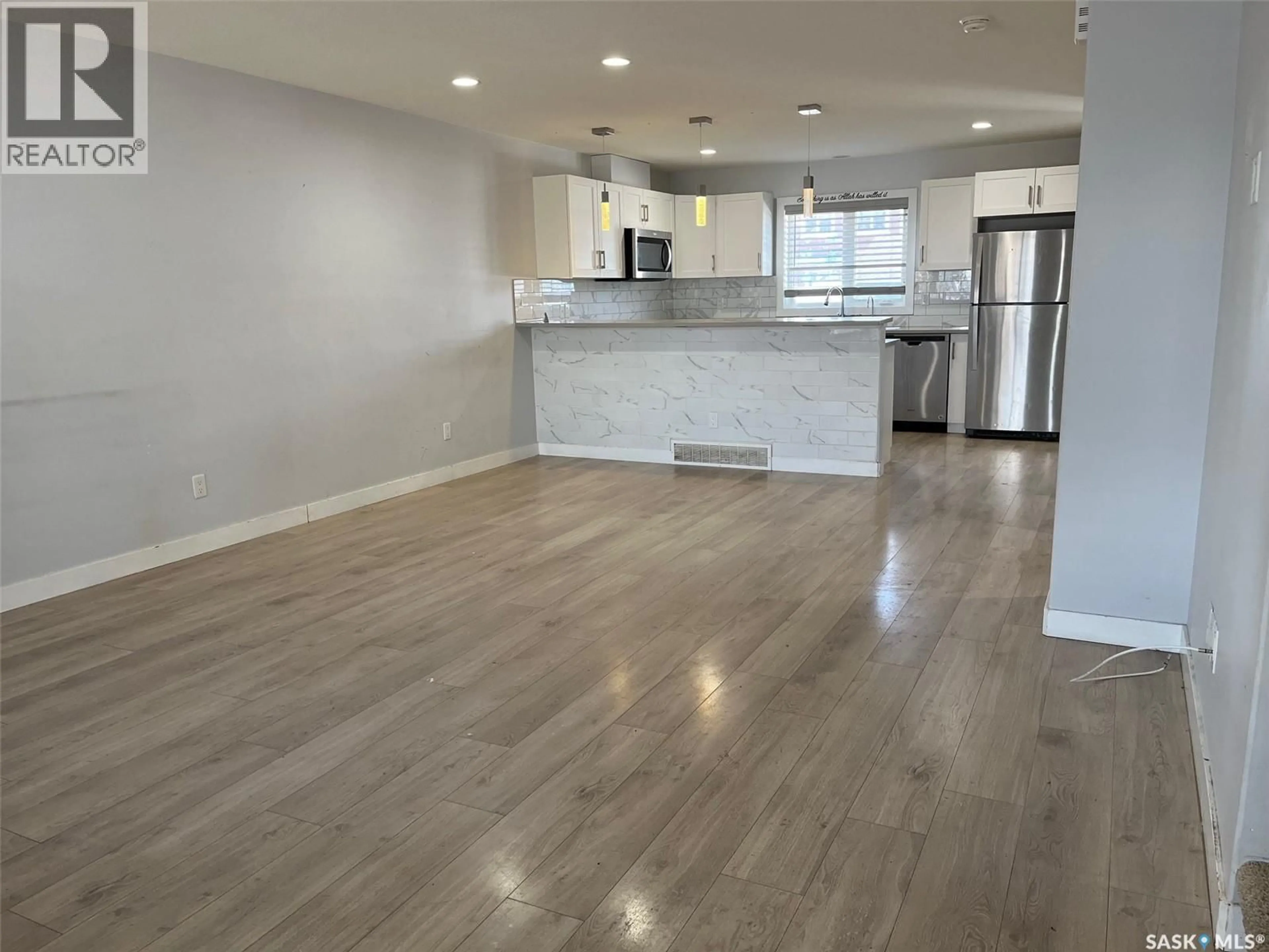Open concept kitchen, wood/laminate floor for 5652 PREFONTAINE AVENUE, Regina Saskatchewan S4W0M8