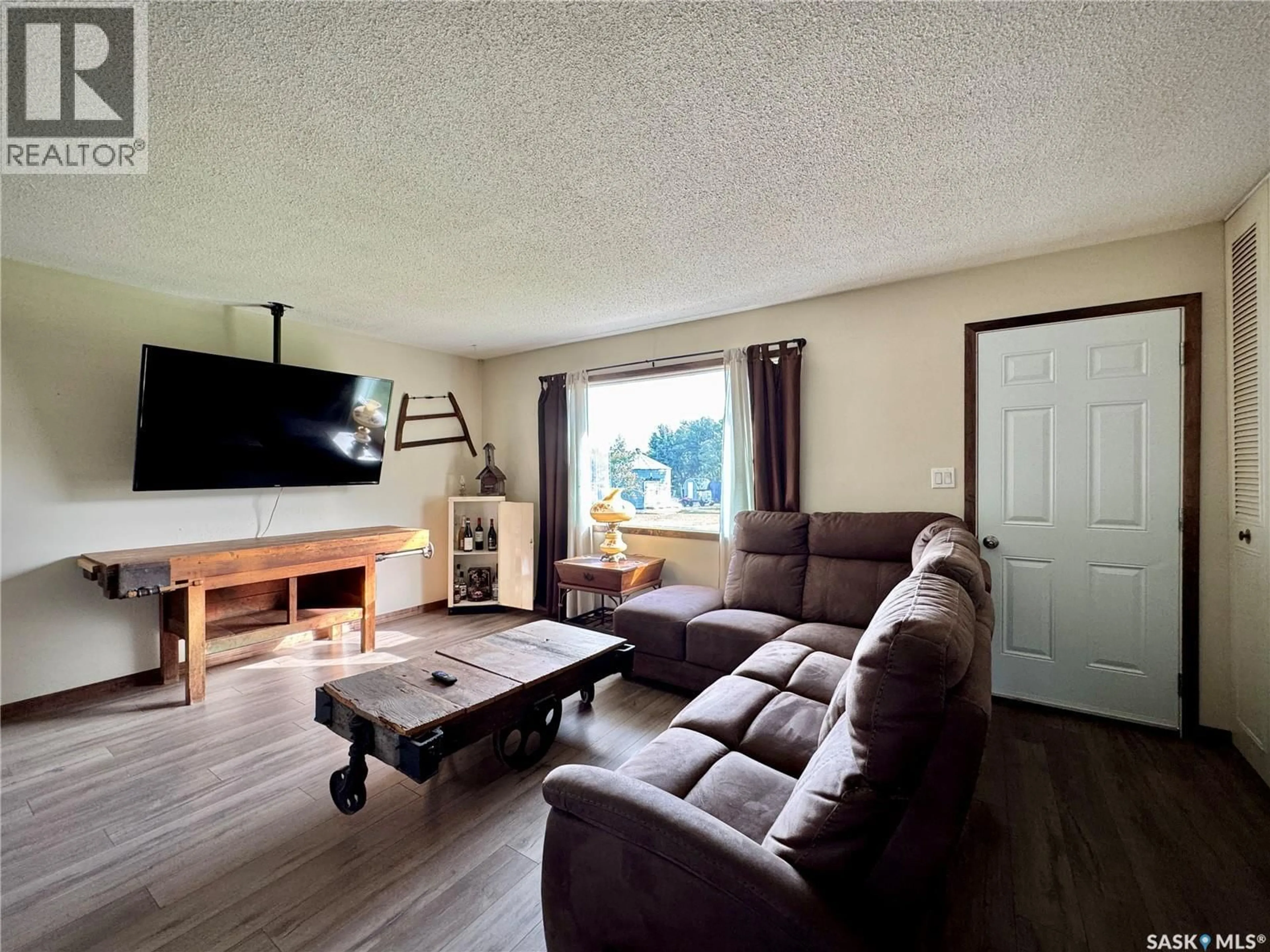 Living room with furniture, wood/laminate floor for PRAIRIE CREST ACRES, Cana Rm No. 214 Saskatchewan S0A2P0