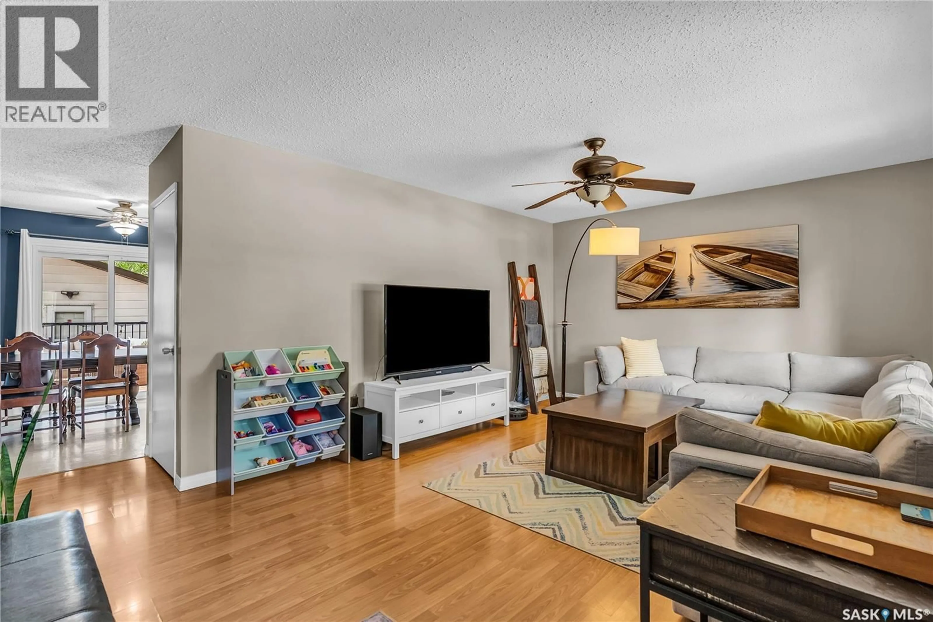 Living room with furniture, wood/laminate floor for 2414 MCPHERSON AVENUE, Saskatoon Saskatchewan S7J0S9