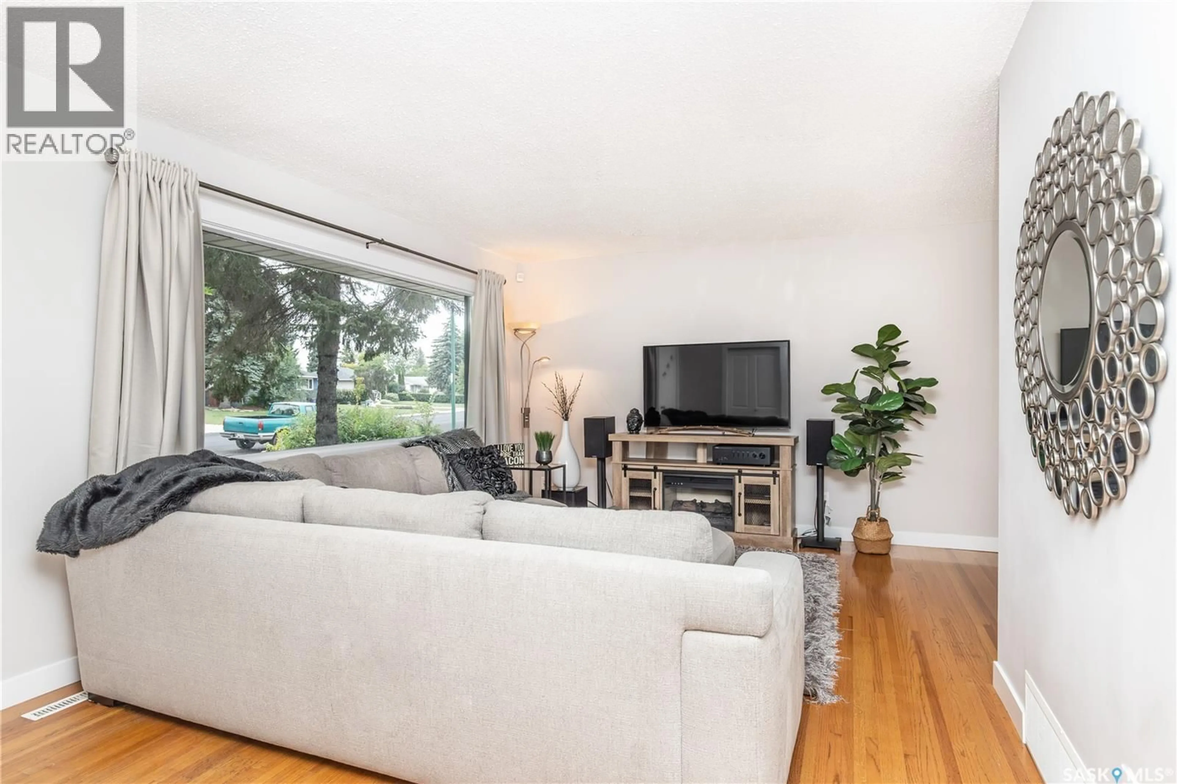 Living room with furniture, wood/laminate floor for 110 WILSON CRESCENT, Saskatoon Saskatchewan S7J2L5
