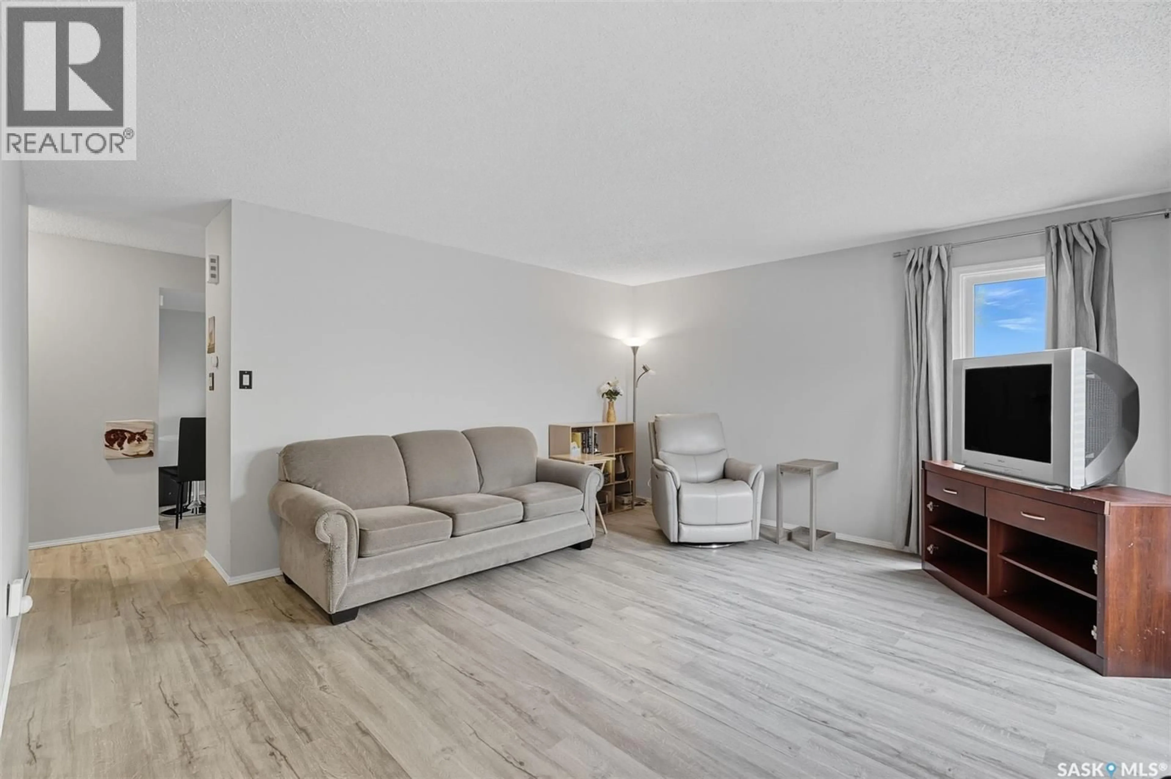 Living room with furniture, wood/laminate floor for 103 & 105 HEDLEY STREET, Saskatoon Saskatchewan S7N4G4