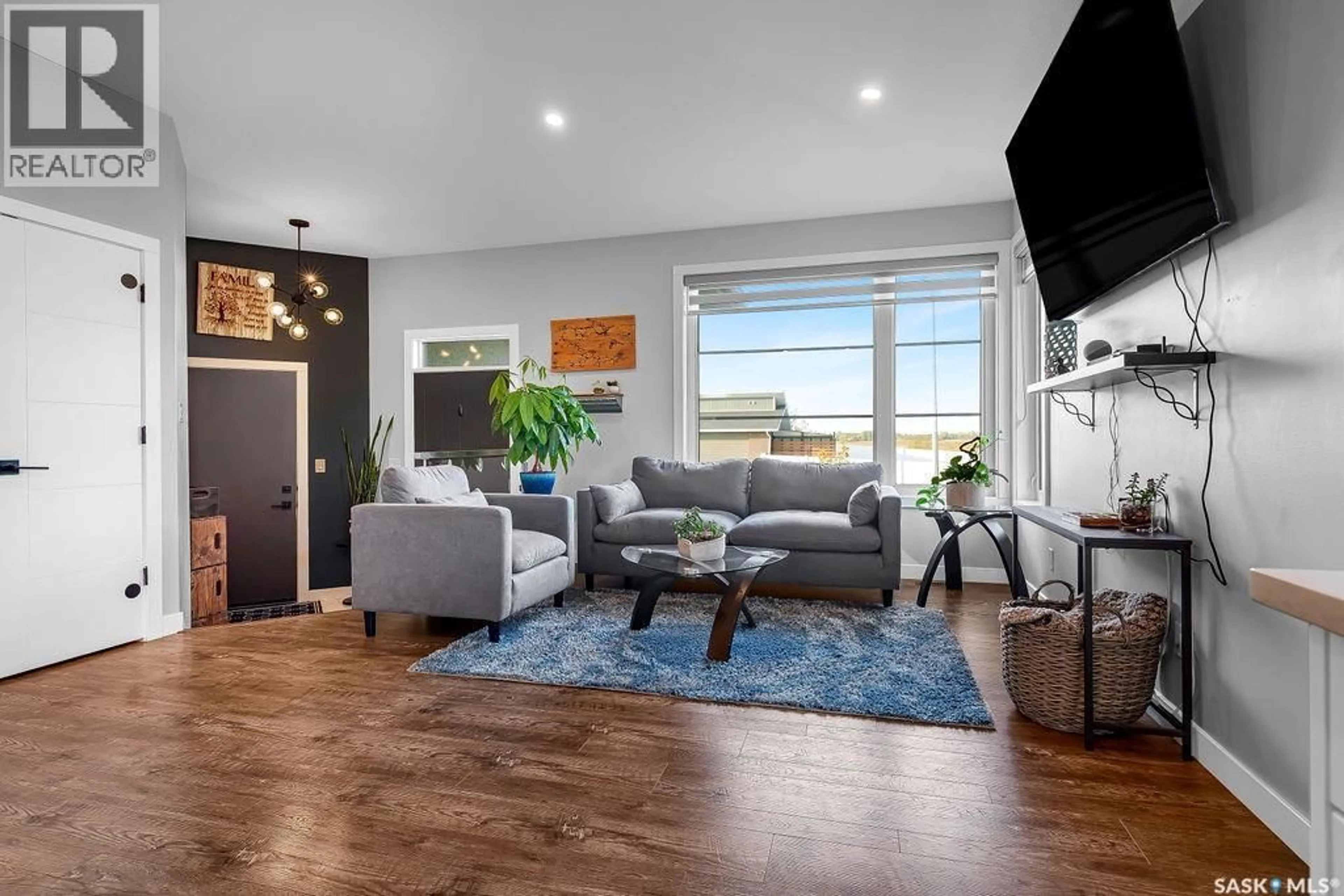Living room with furniture, wood/laminate floor for 103 VESTOR DRIVE, Pilot Butte Saskatchewan S0G3Z0