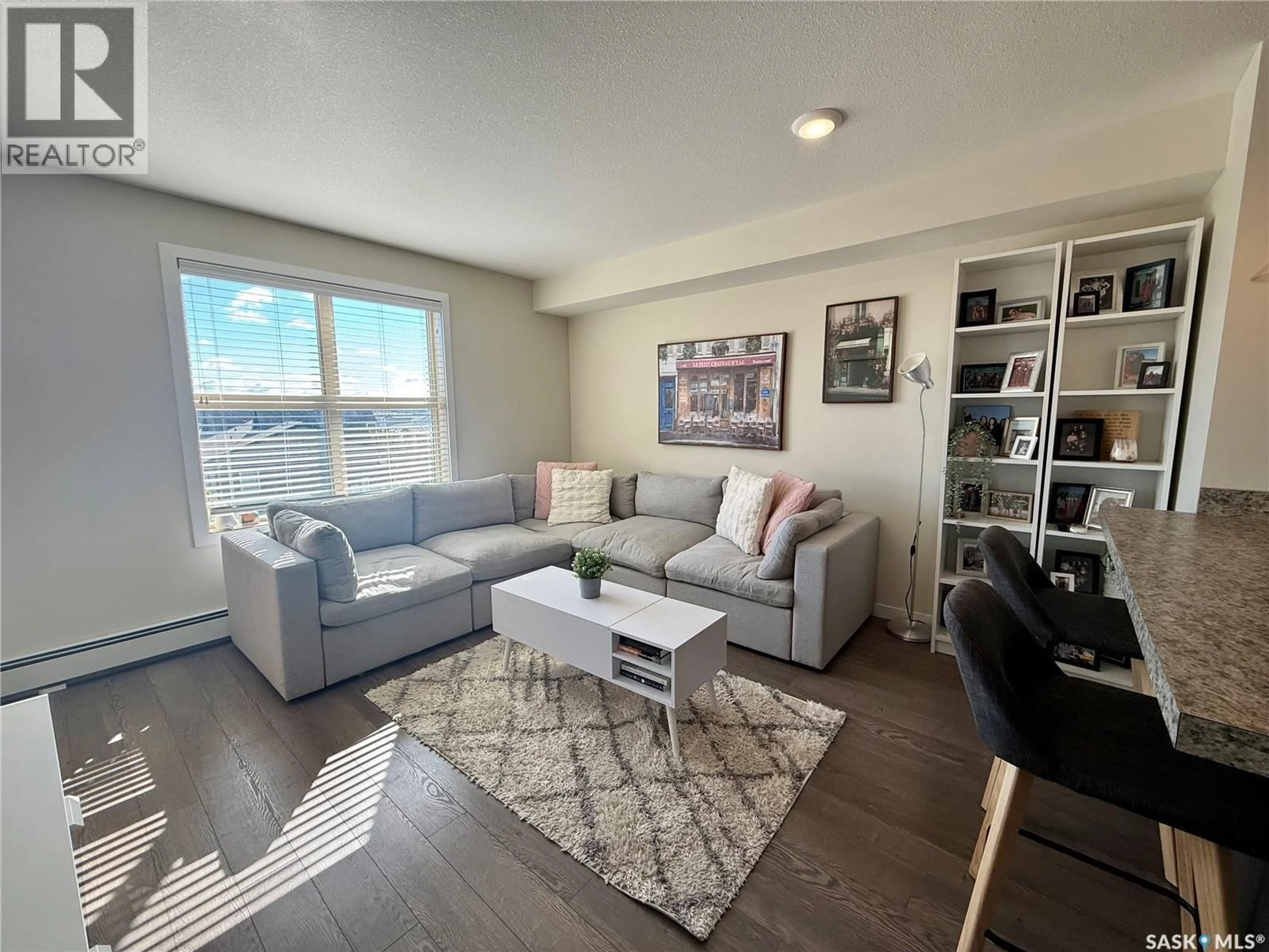Living room with furniture, wood/laminate floor for 5500 - 1425 MITCHINSON WAY, Regina Saskatchewan S4W0N9