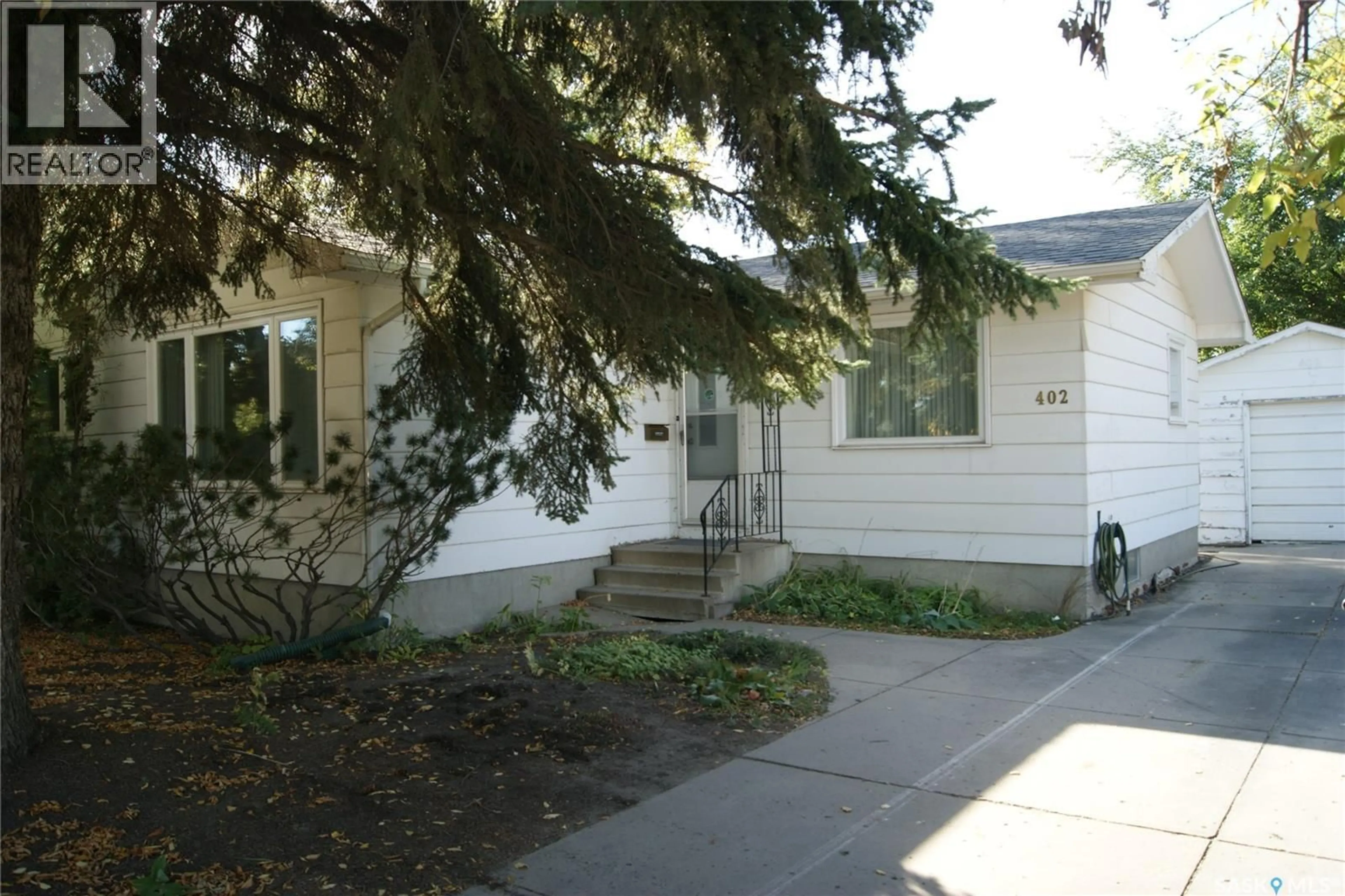 Home with vinyl exterior material, street for 402 MCKERCHER DRIVE, Saskatoon Saskatchewan S7H3W5