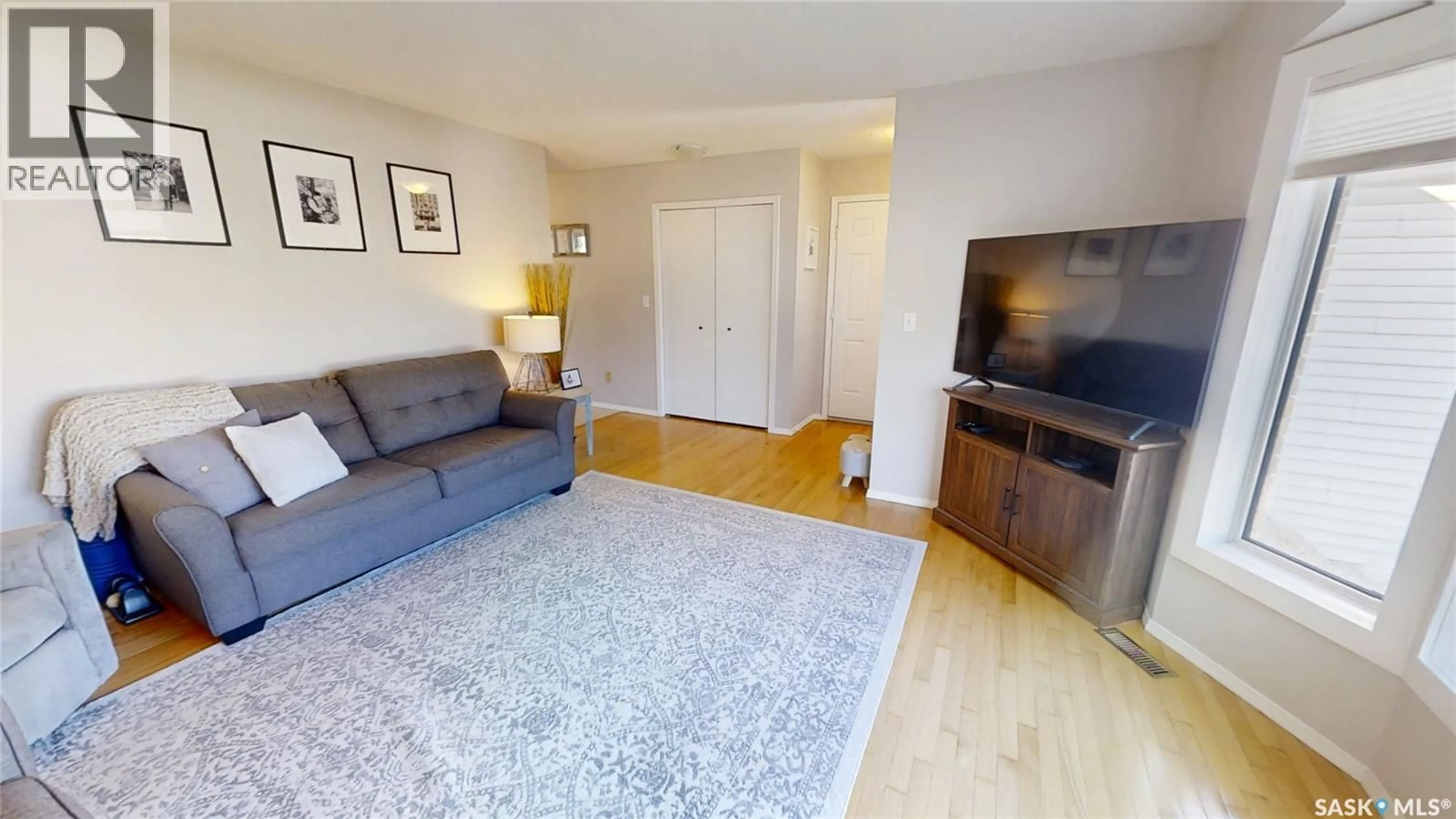 Living room with furniture, wood/laminate floor for 206 PEREHUDOFF COURT, Saskatoon Saskatchewan S7N4H1