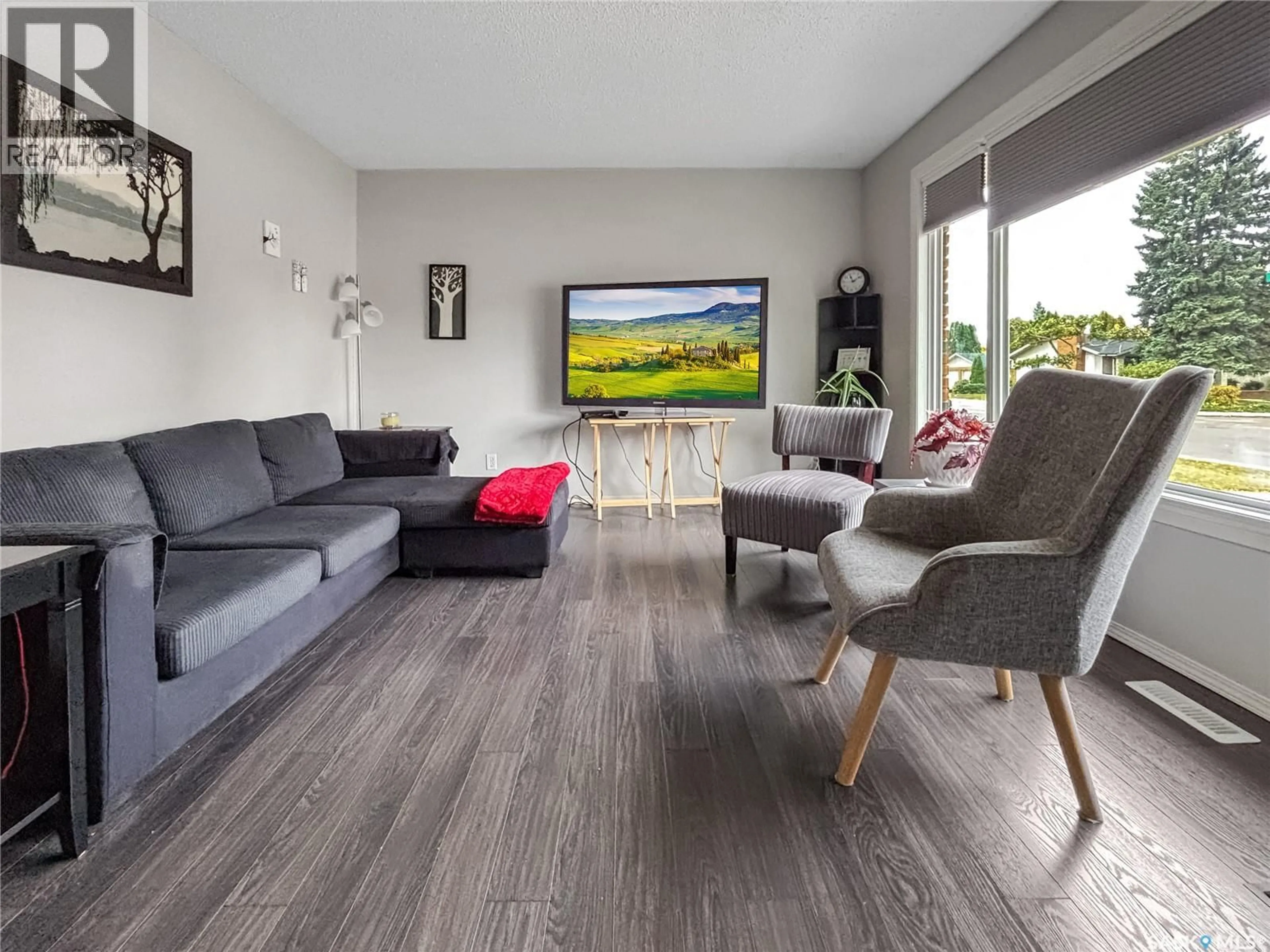 Living room with furniture, wood/laminate floor for 114 COCKBURN CRESCENT, Saskatoon Saskatchewan S7L5R9