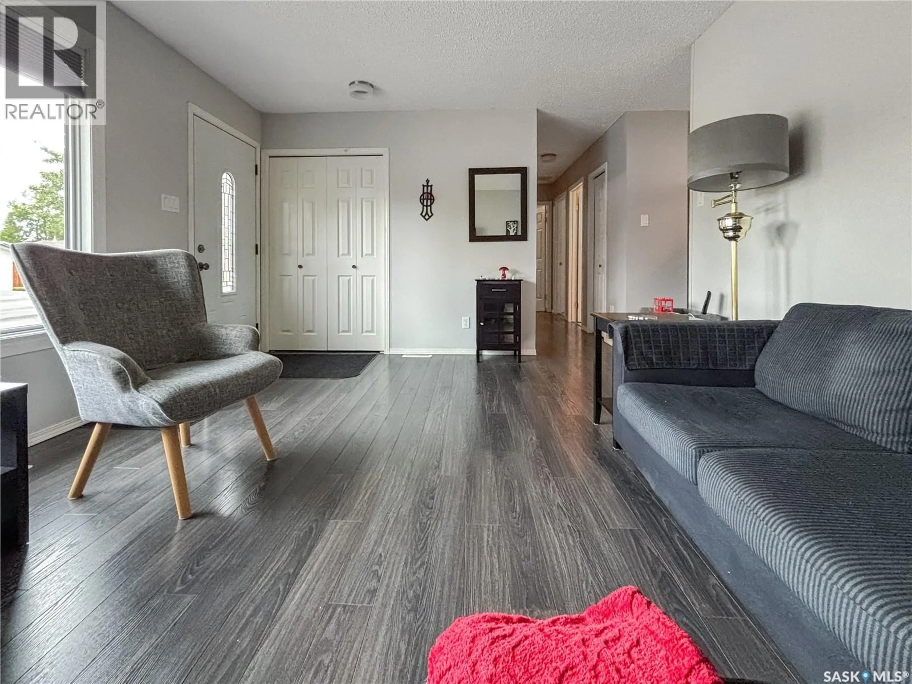 Living room with furniture, wood/laminate floor for 114 COCKBURN CRESCENT, Saskatoon Saskatchewan S7L5R9