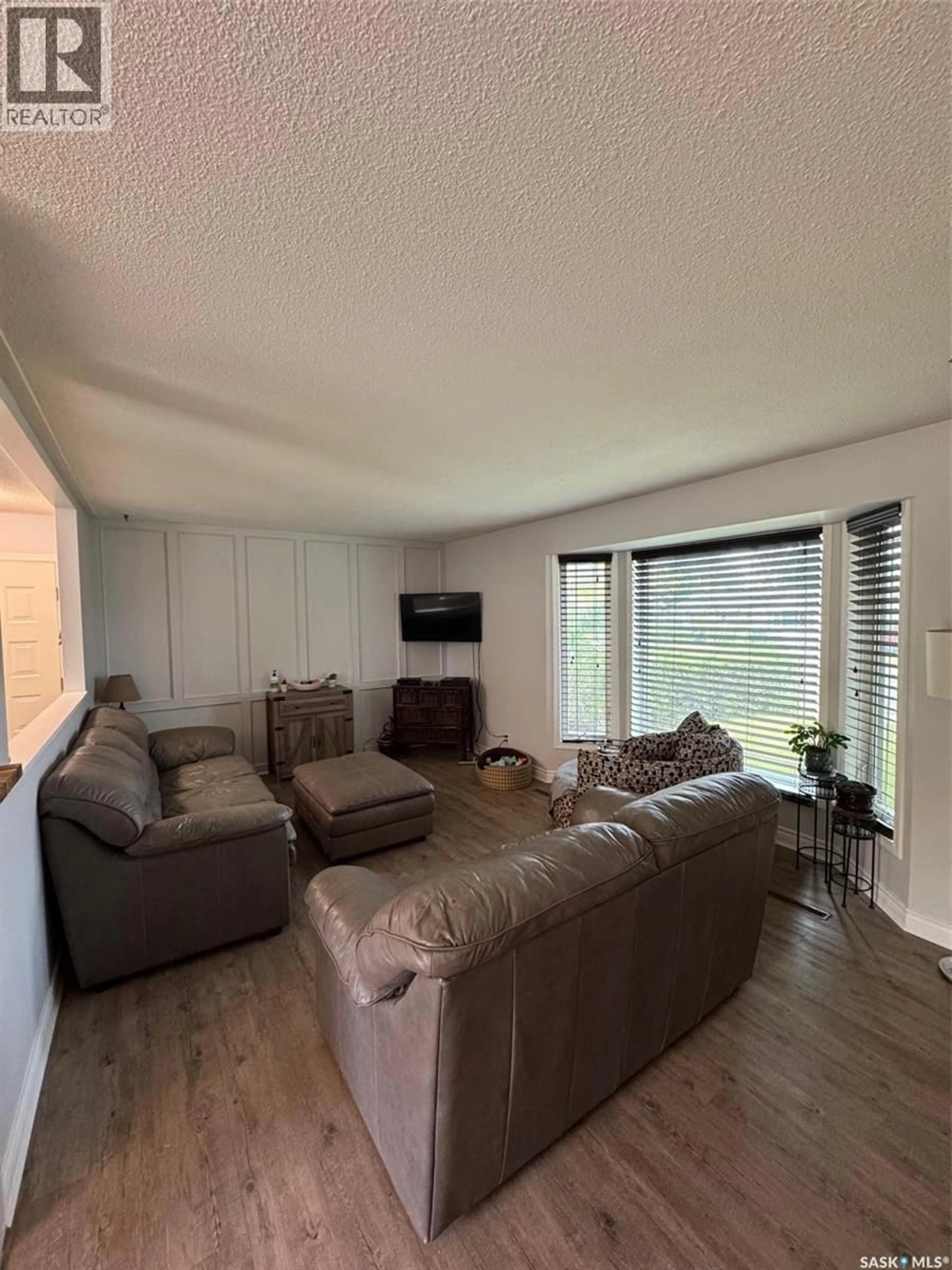 Living room with furniture, wood/laminate floor for 1811 91ST STREET, North Battleford Saskatchewan S9A0A6