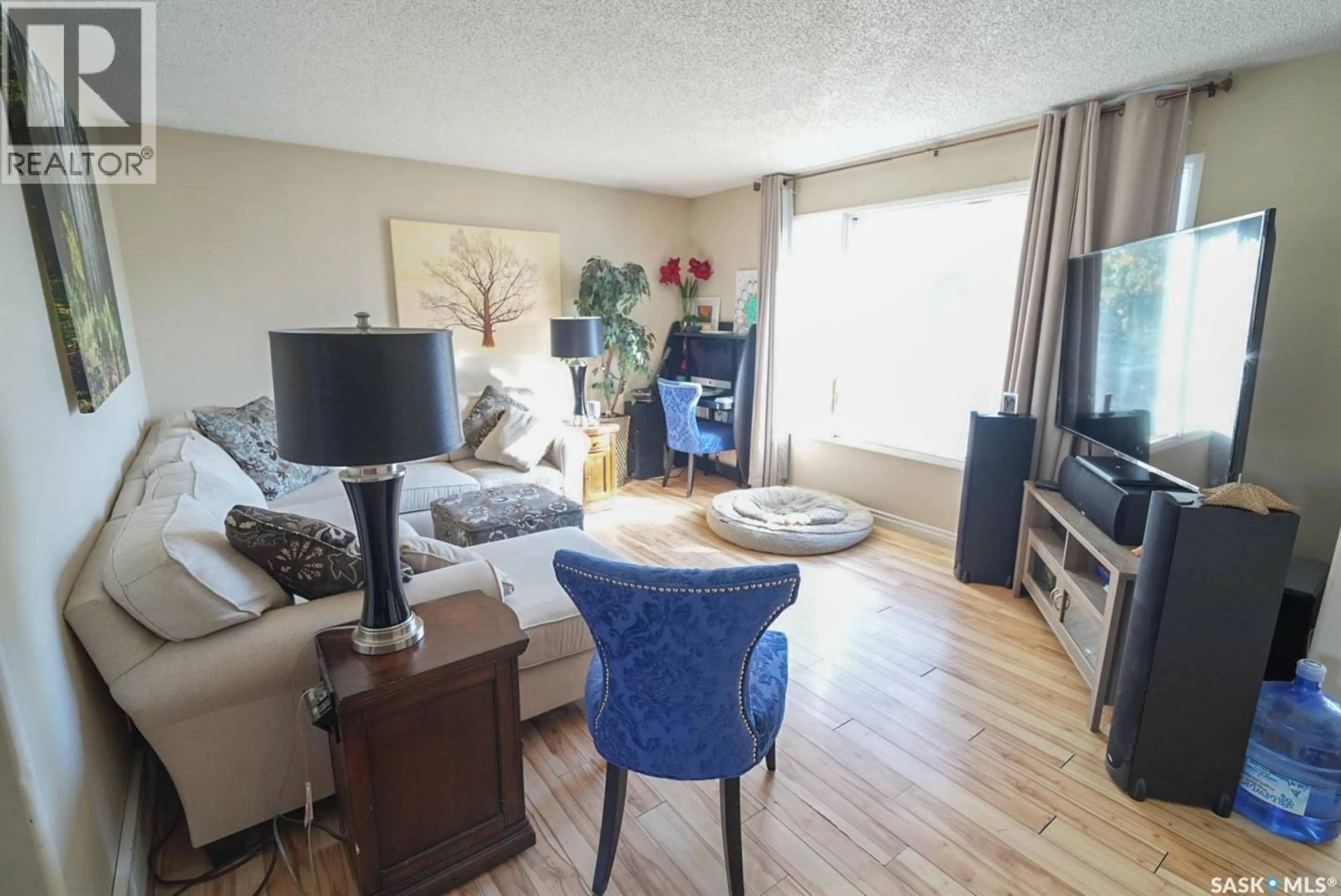Living room with furniture, wood/laminate floor for 106 CLANCY DRIVE, Saskatoon Saskatchewan S7M4L2