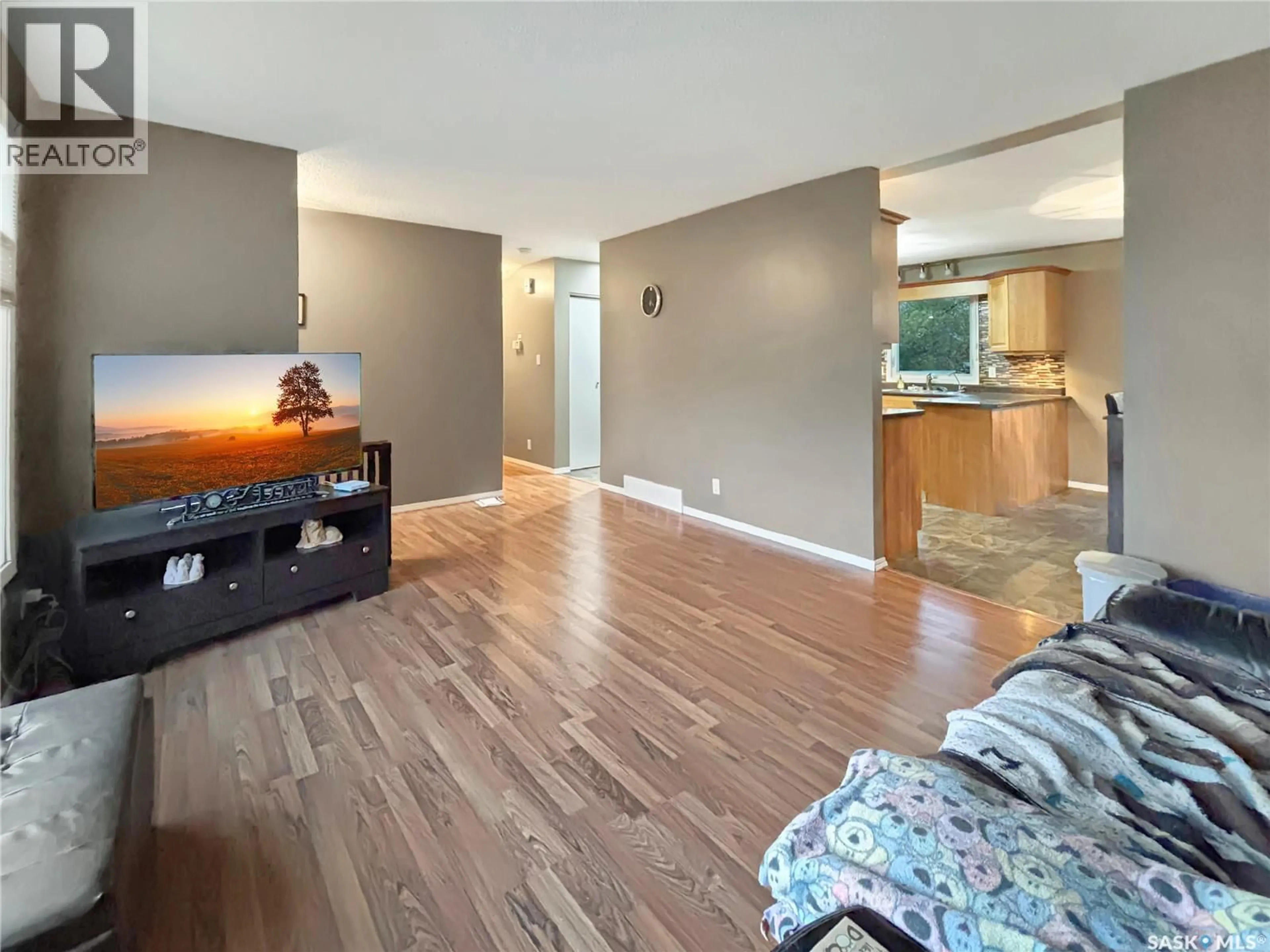 Living room with furniture, wood/laminate floor for 9807 21ST AVENUE, North Battleford Saskatchewan S9A3K4
