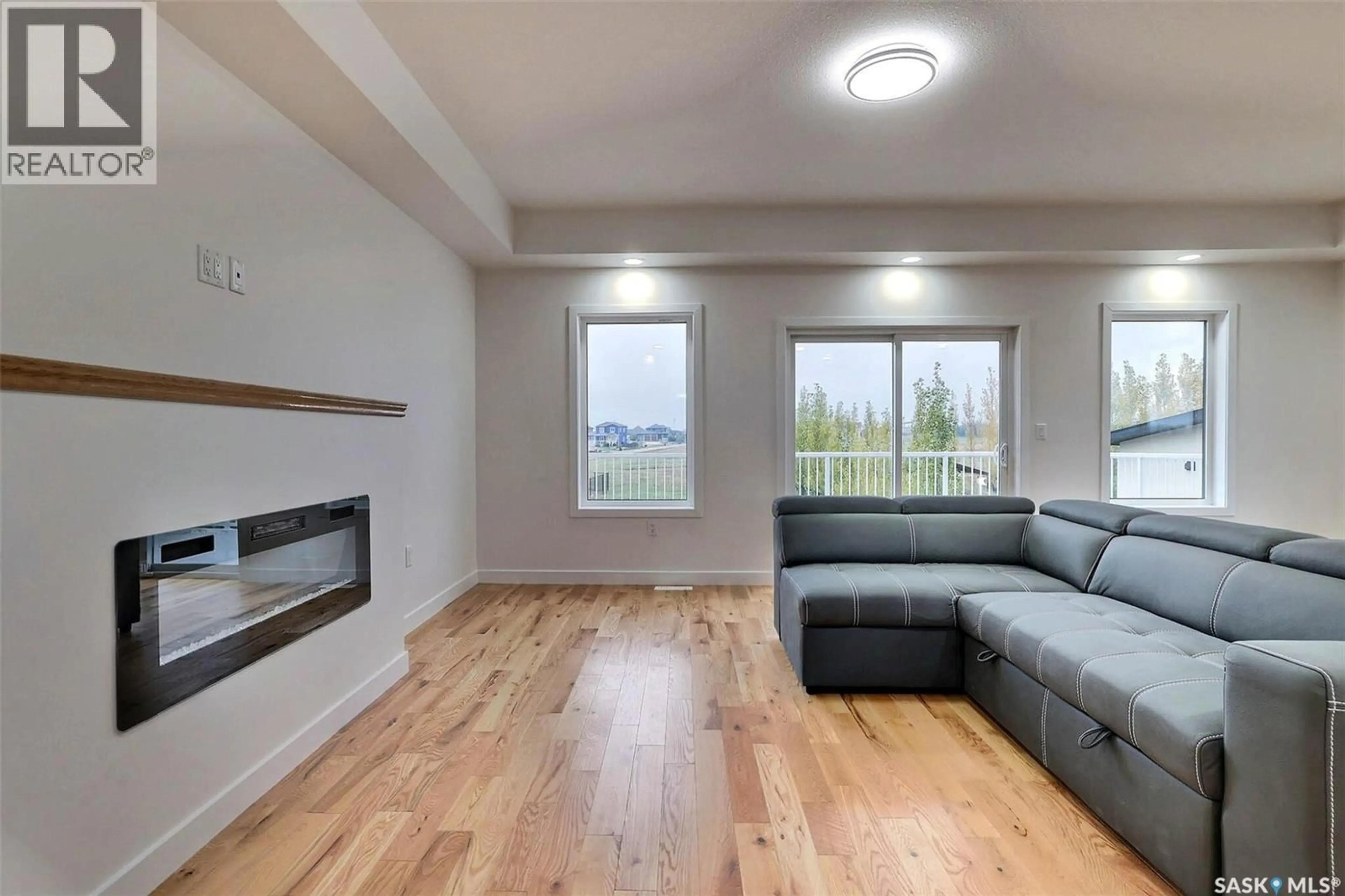 Living room with furniture, wood/laminate floor for 716 EMERALD PARK ROAD, Edenwold Rm No.158 Saskatchewan S4L0C4